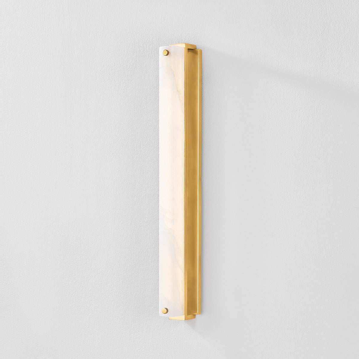 Close-up of the Edgemere Wall Sconce in aged brass showing the arm curve and shade silhouette.