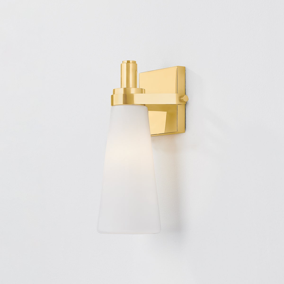 Close-up of the Trude Wall Sconce in aged brass showing the arm curve and shade silhouette.