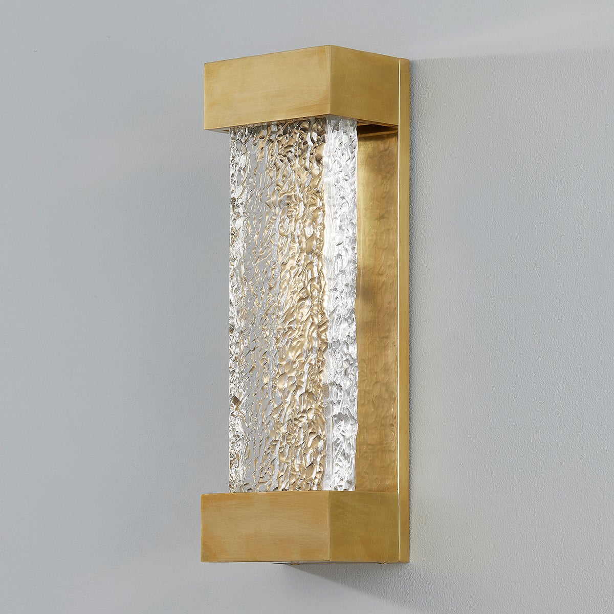 Wharton Wall Sconce 5" x 15" in aged brass shown from the front to reveal the arm curve and shade silhouette.