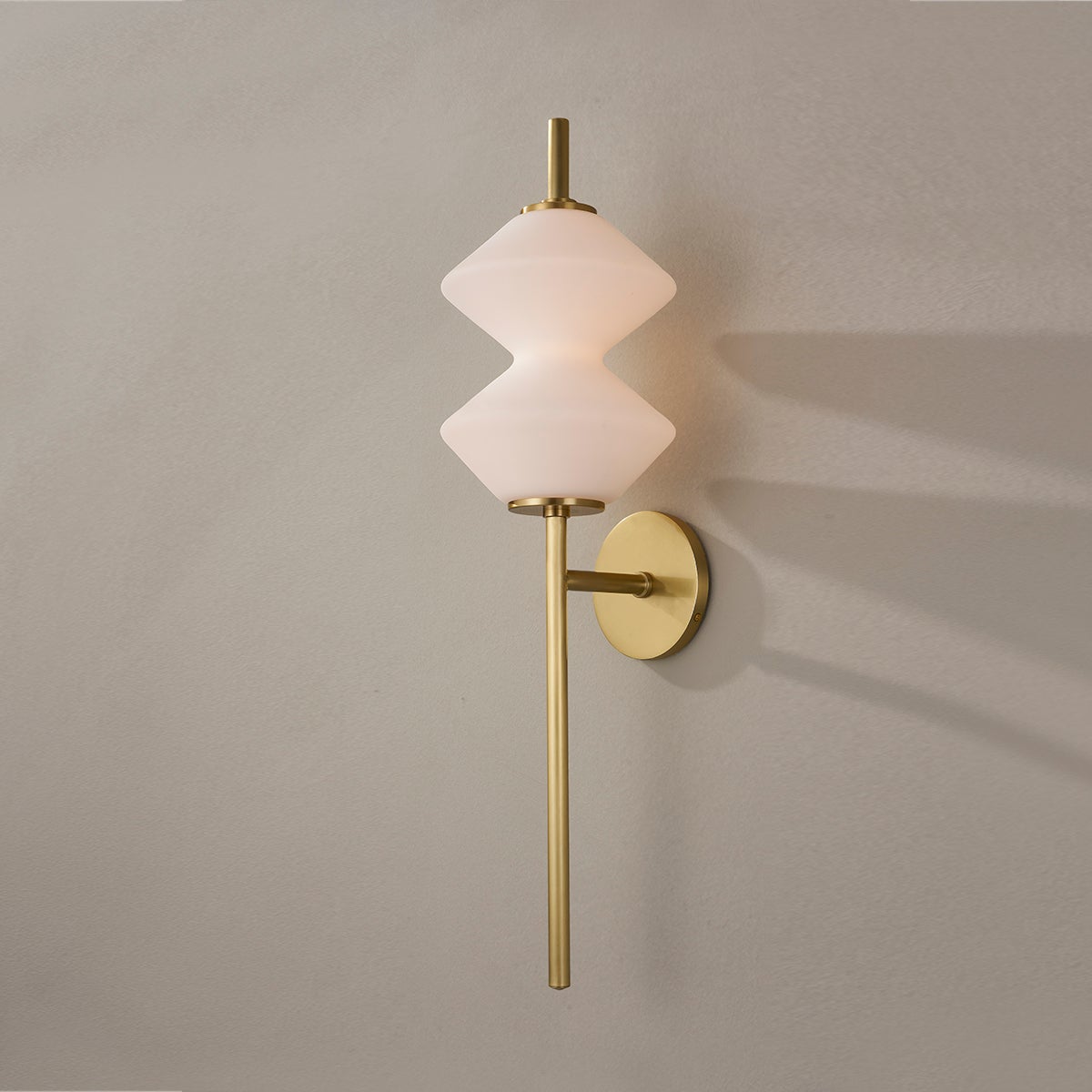 Barrow Wall Sconce in aged brass shown from the front to reveal the arm curve and shade silhouette.