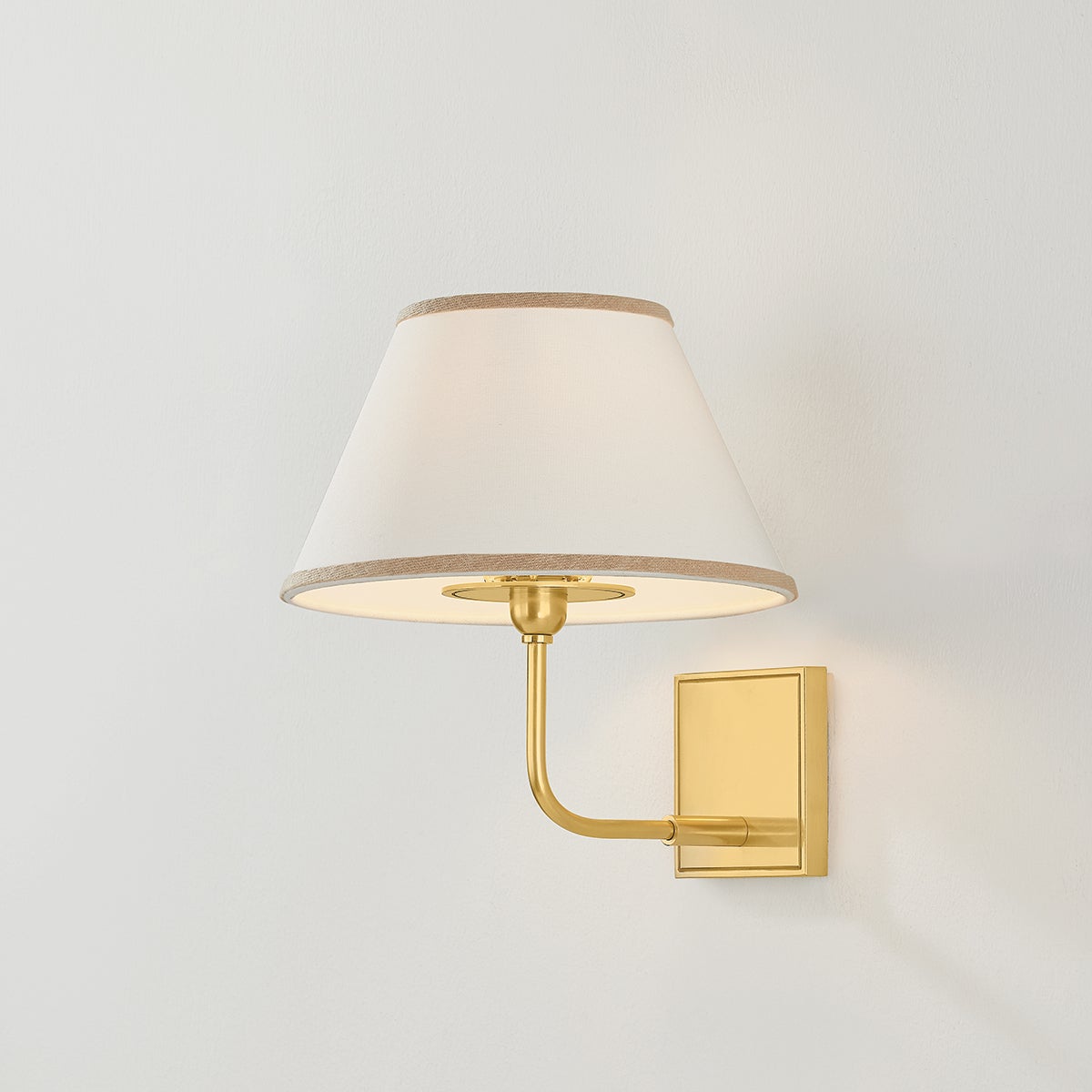 Durland Wall Sconce in aged brass shown from the front to reveal the arm curve and shade silhouette.