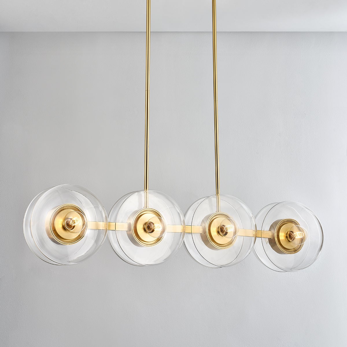 Close-up of the Kert Linear in aged brass showing the extended frame and shade array.