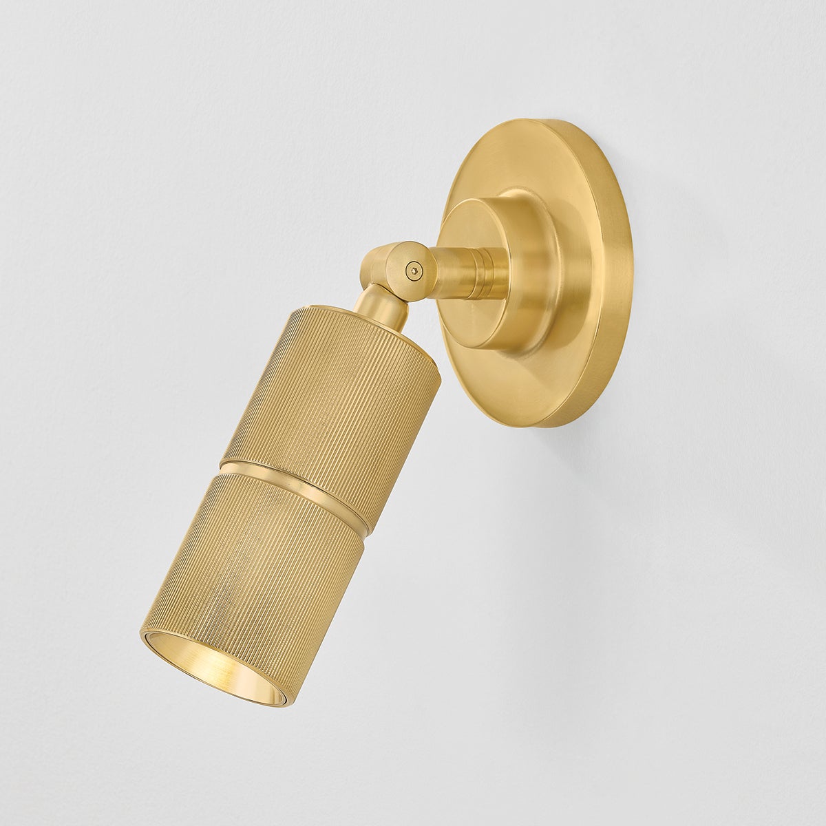 Close-up of the Truett Wall Sconce in aged brass showing the arm curve and shade silhouette.