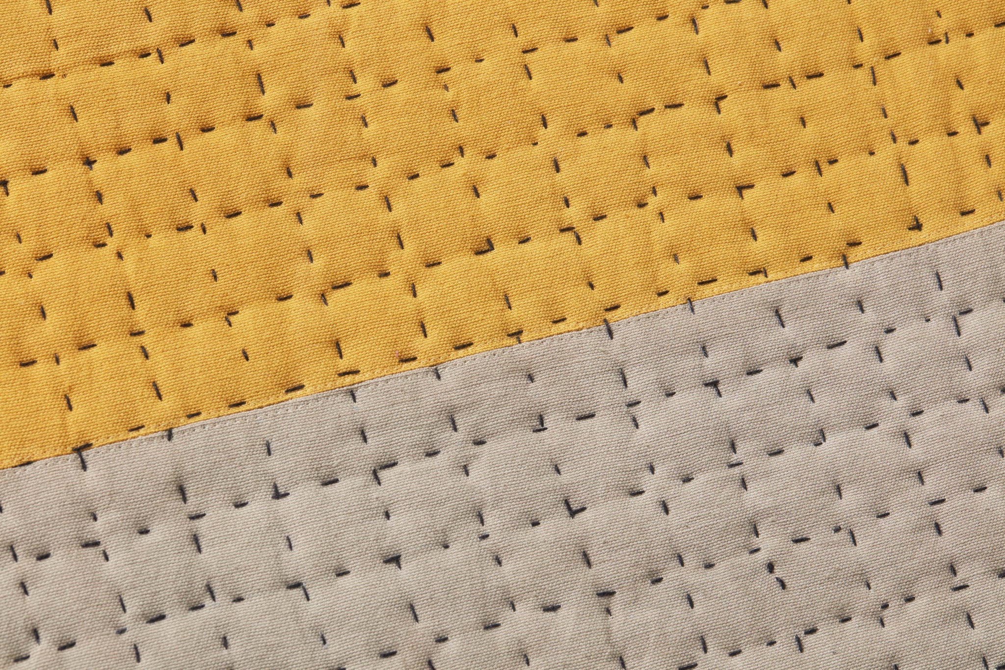 Proof Read Gold / Grey Rug Art shown from a different angle to reveal its pattern.