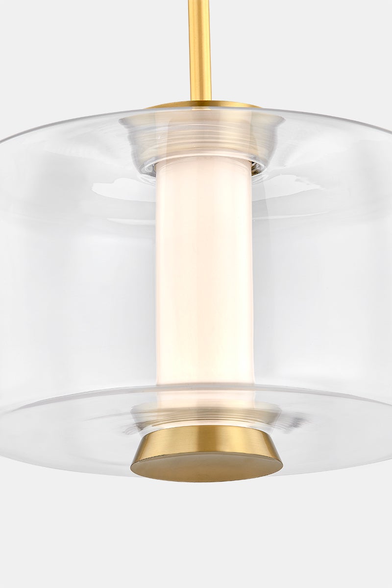 Close-up of the Beau Pendant 15" in aged brass showing the shade shape and metal detail.
