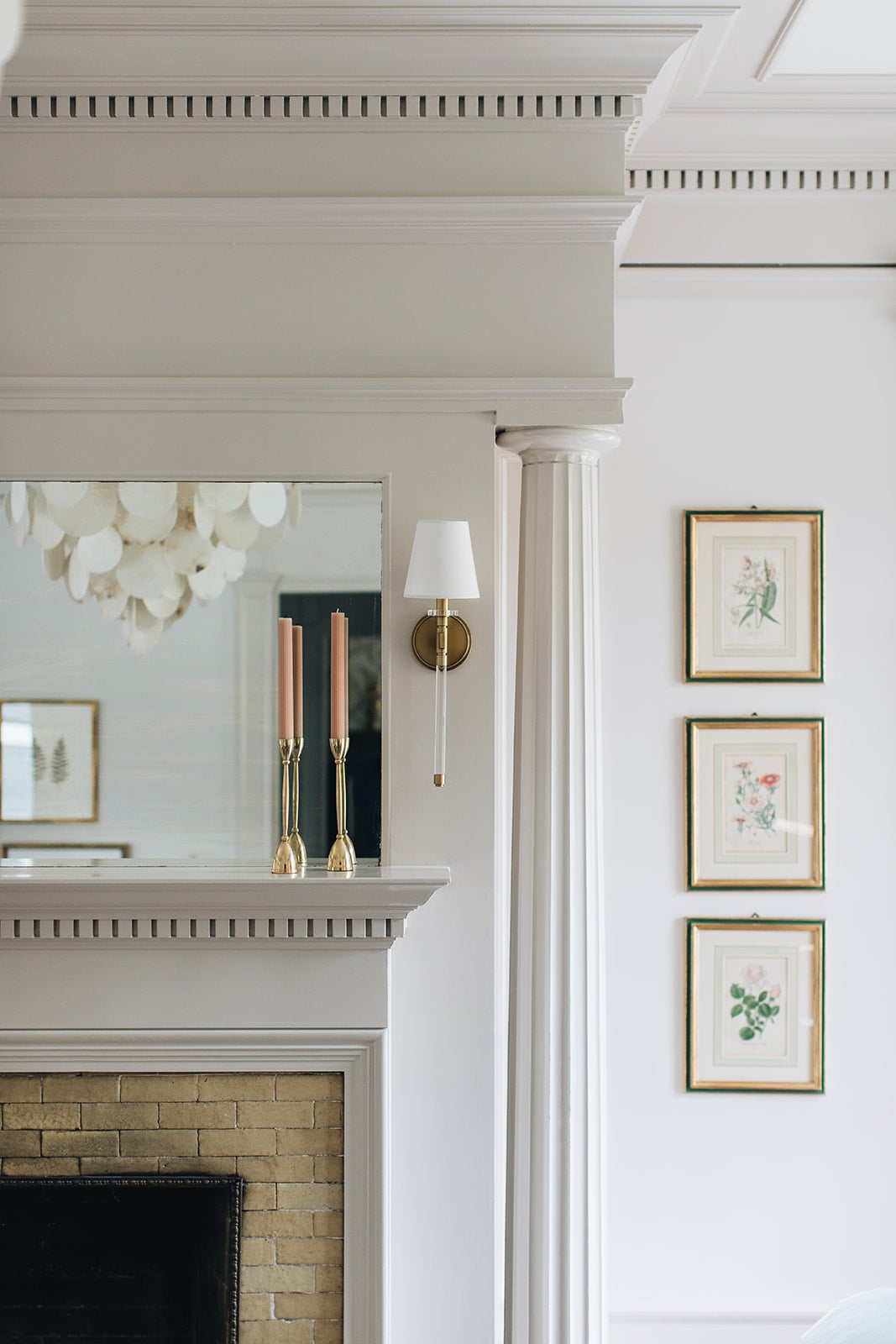 Blixen Wall Sconce in aged brass styled in a curated living room for warm, layered light at Laurie Yapp Home.