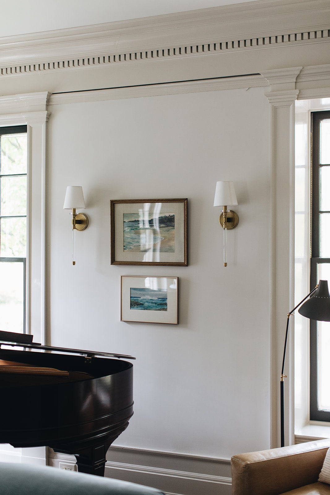 Blixen Wall Sconce in aged brass styled in a warmly lit hallway for warm, layered light at Laurie Yapp Home.