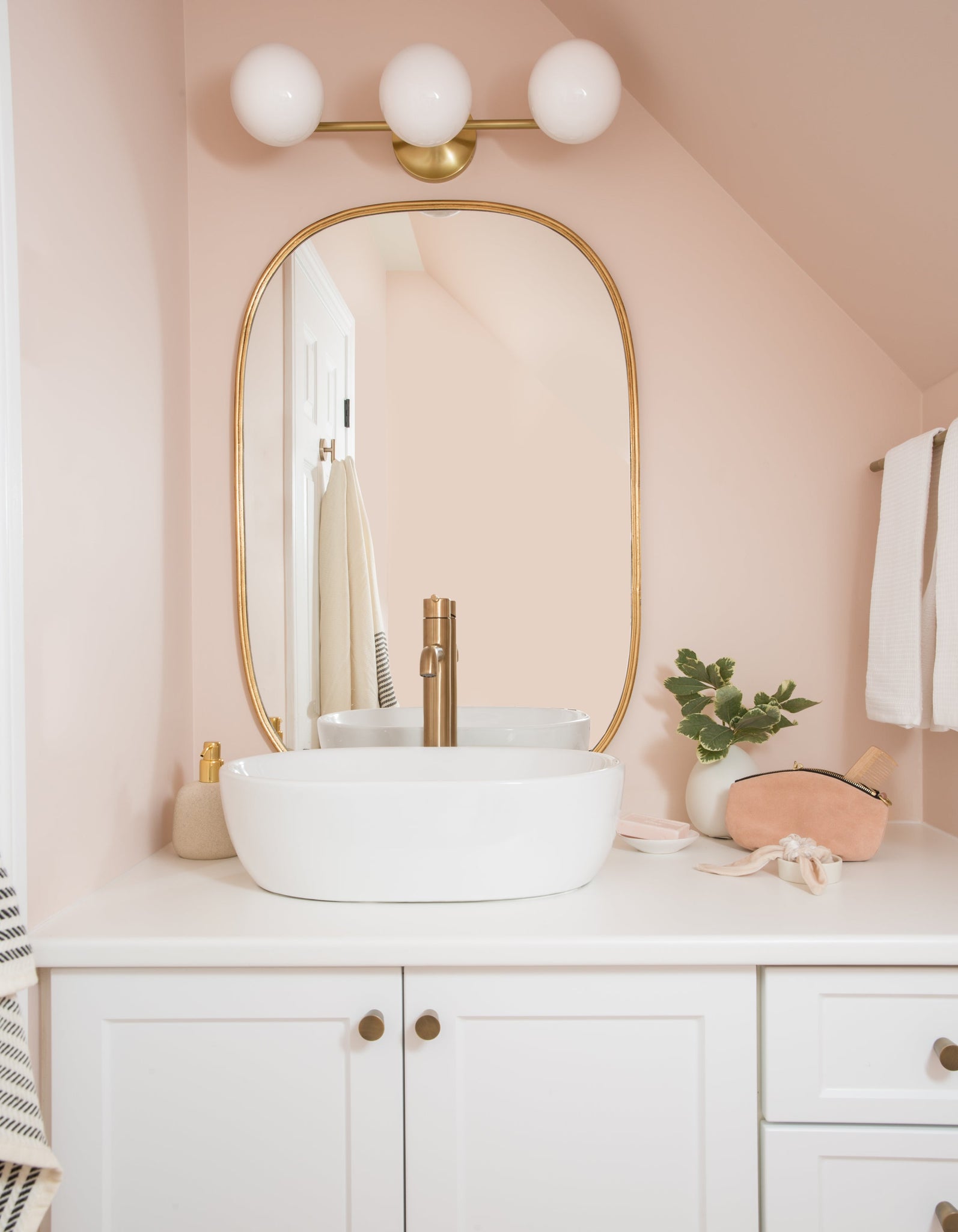 Fleming Bath And Vanity 20.75" in aged brass styled in a bright bathroom for warm, layered light at Laurie Yapp Home.