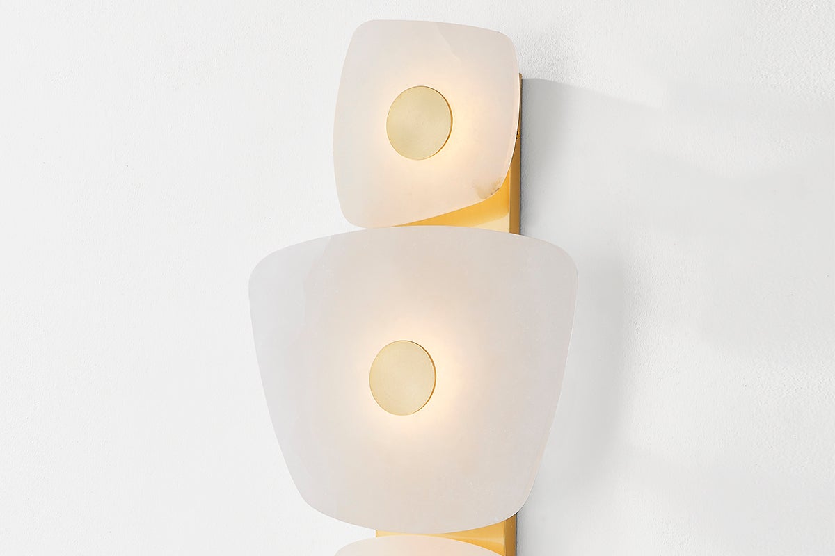 Close-up of the Holmdel Wall Sconce in aged brass showing the arm curve and shade silhouette.
