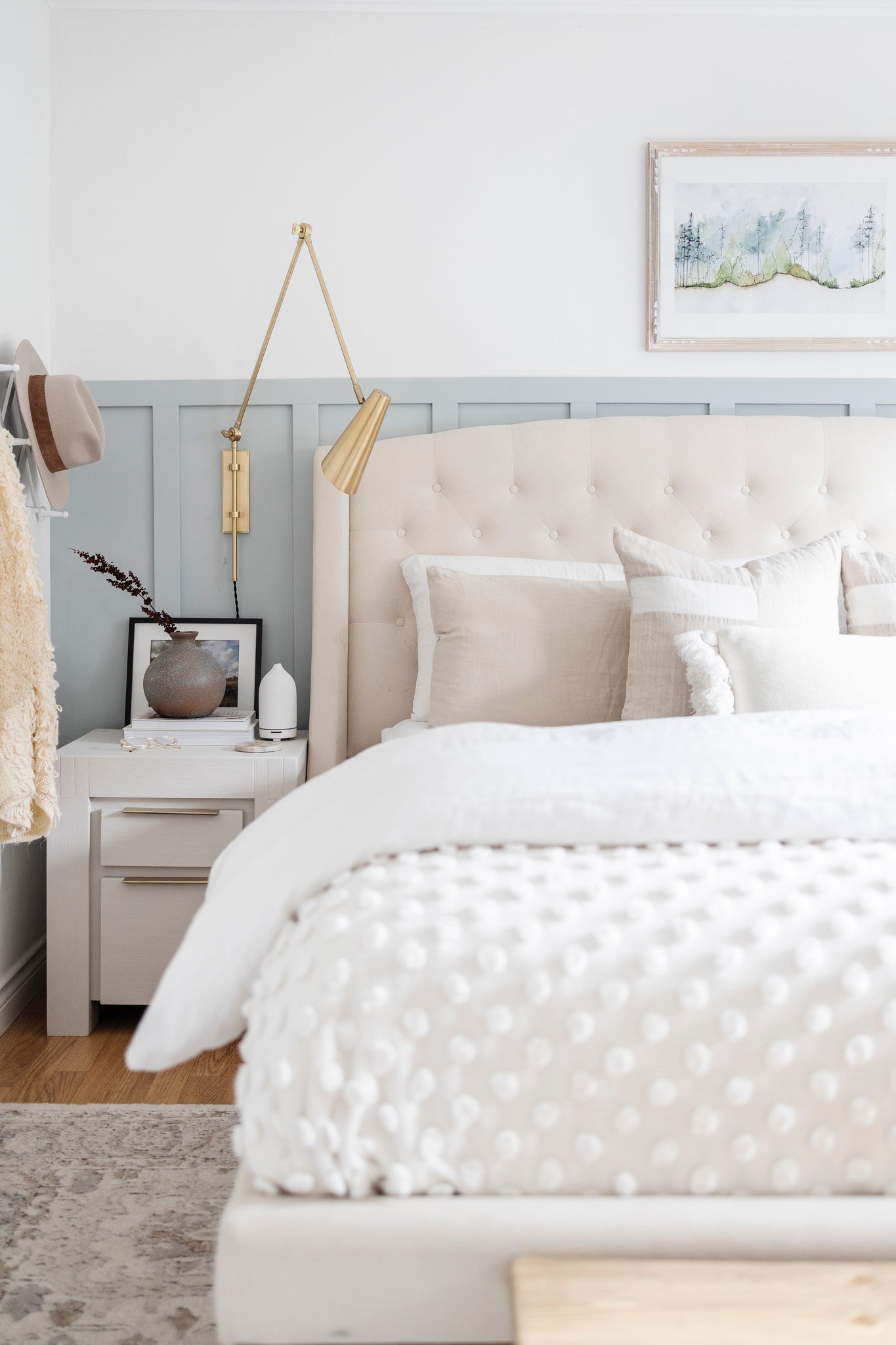Lorne Plug-In Sconce in aged brass styled in a reading nook for warm, layered light at Laurie Yapp Home.