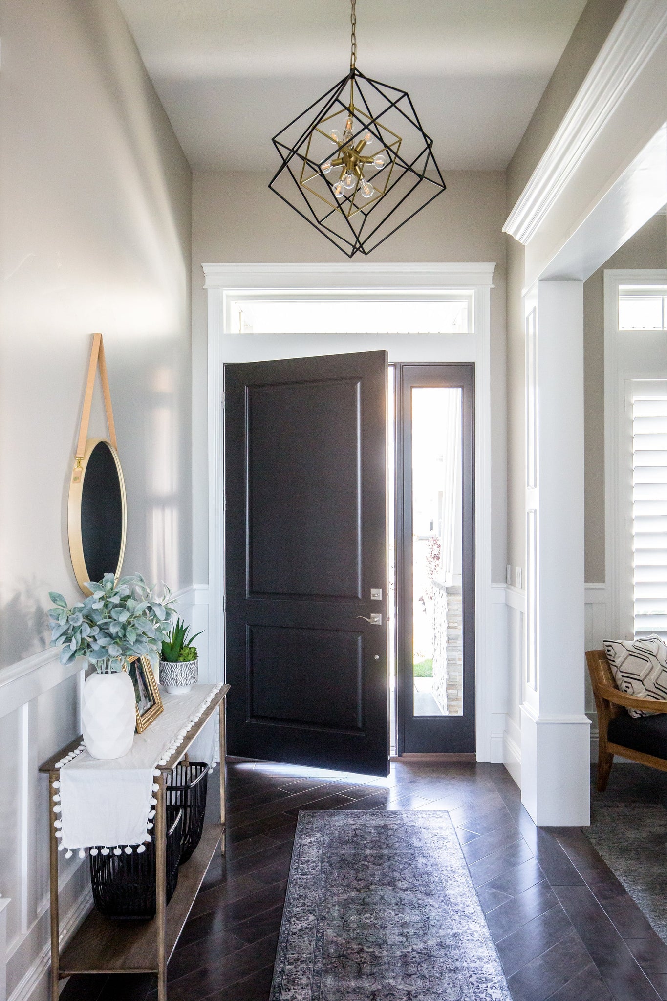 Roundout Chandelier 26" in aged brass styled in a two-story entry for warm, layered light at Laurie Yapp Home.