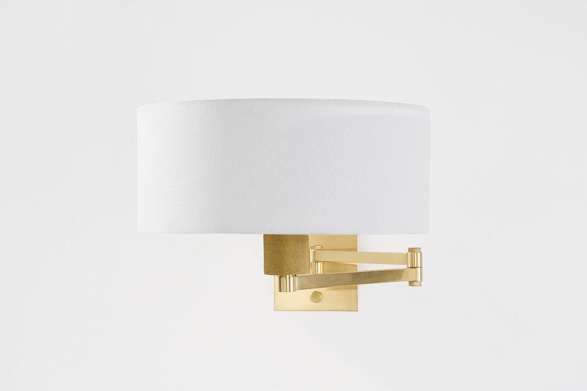Sammy Wall Sconce in aged brass shown from the front to reveal the arm curve and shade silhouette.