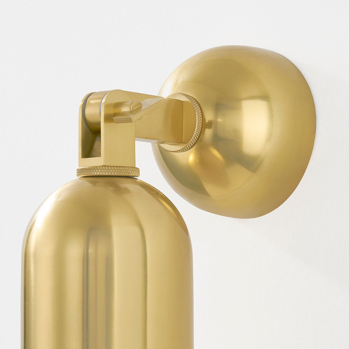 Close-up of the Sturbridge Wall Sconce in aged brass showing the arm curve and shade silhouette.