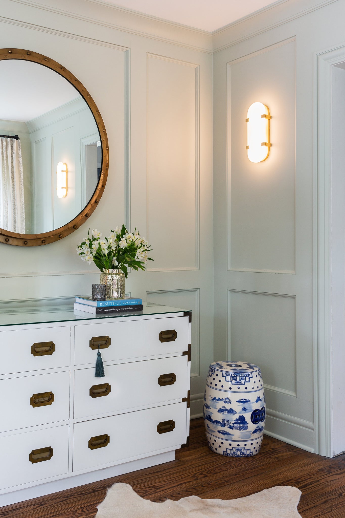 Skylar Wall Sconce 5.75" x 13.75" in aged brass styled in a modern bathroom for warm, layered light at Laurie Yapp Home.