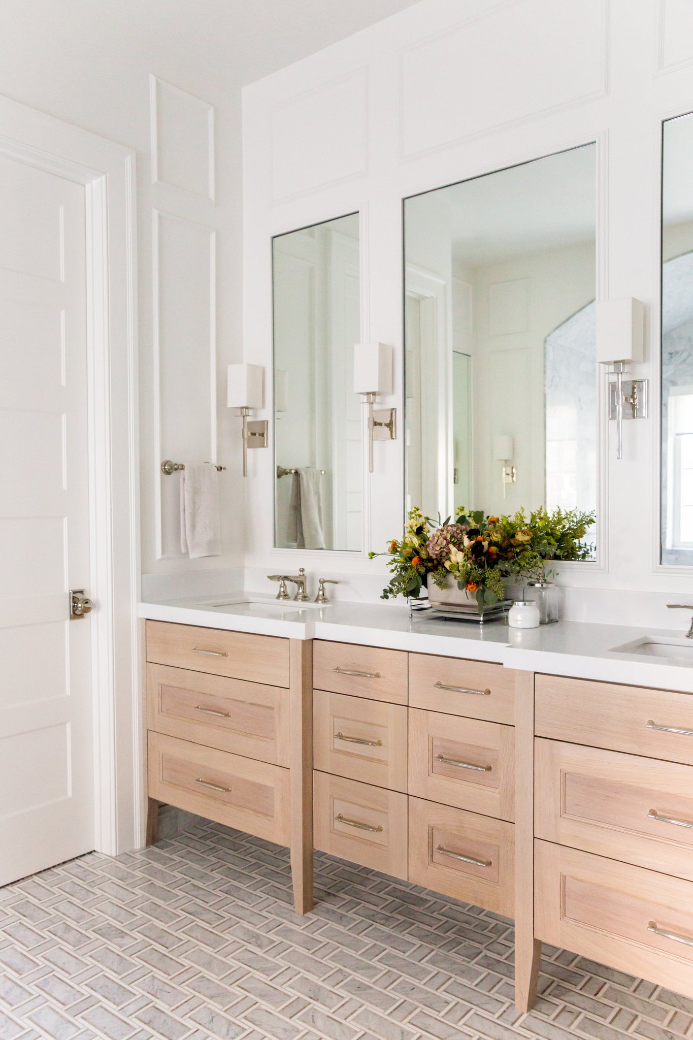 Taunton Wall Sconce in polished nickel styled in a modern bathroom for warm, layered light at Laurie Yapp Home.