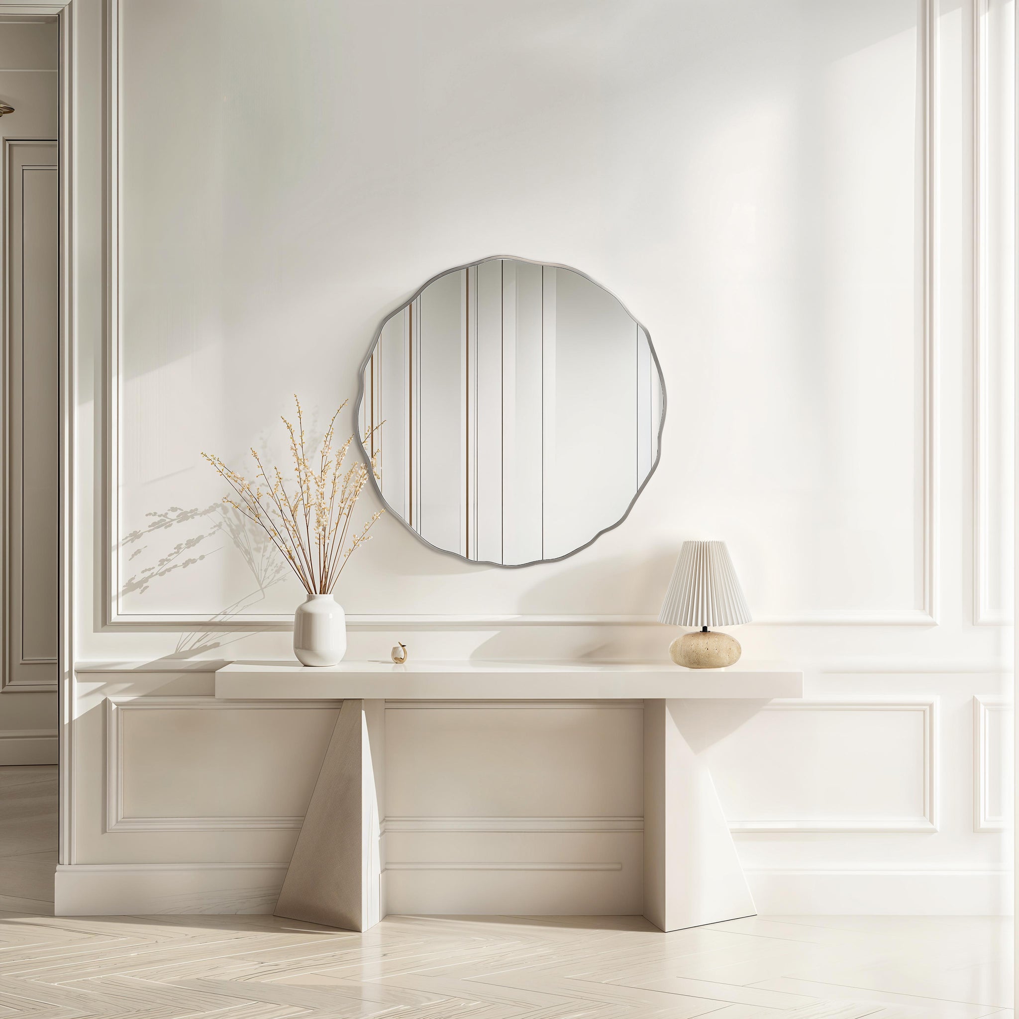 Knox mirror with a scalloped edge, reflecting light in a bright room with a white console table and decorative vase.