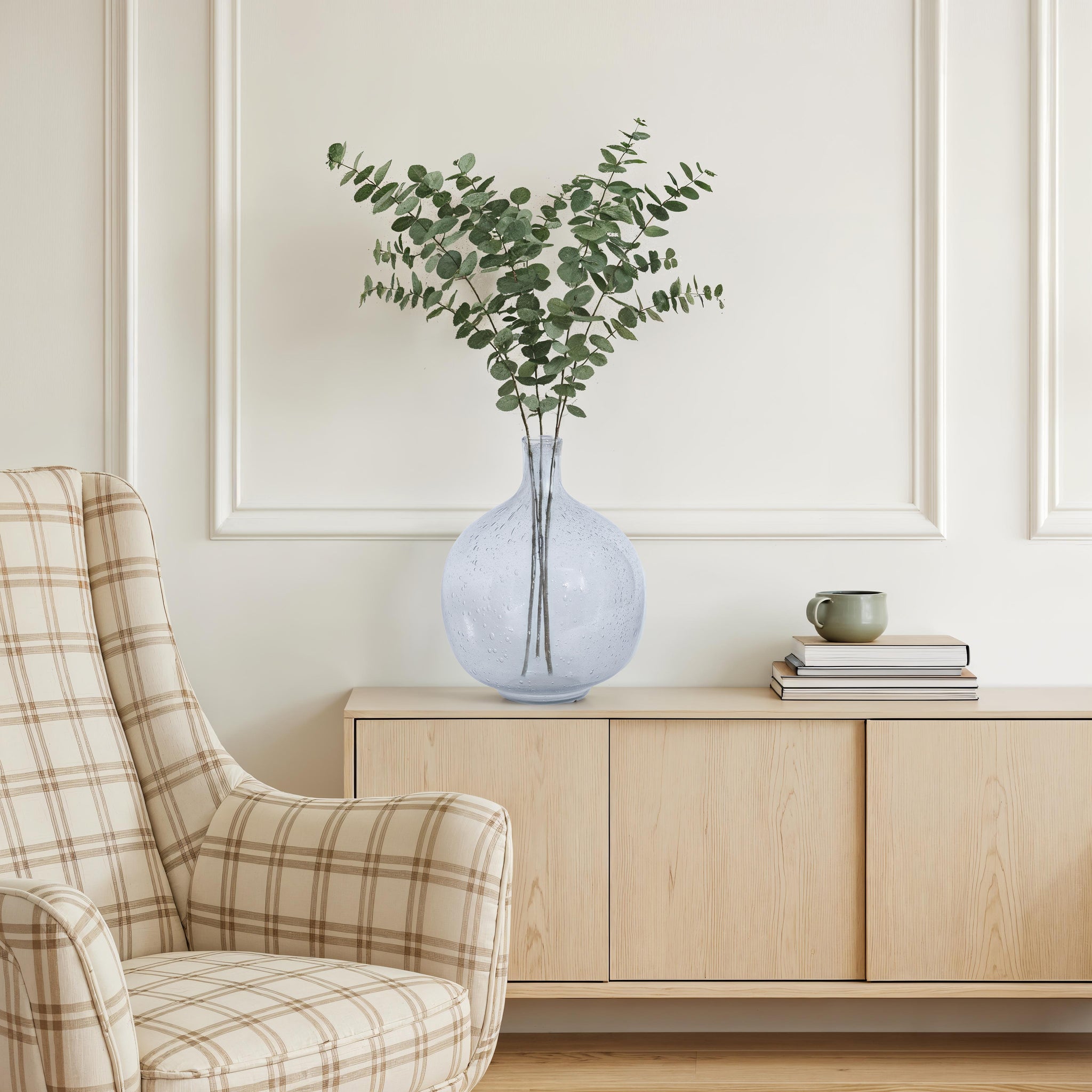 Mirabella vase by Renwil, styled with eucalyptus branches, placed on a wooden cabinet