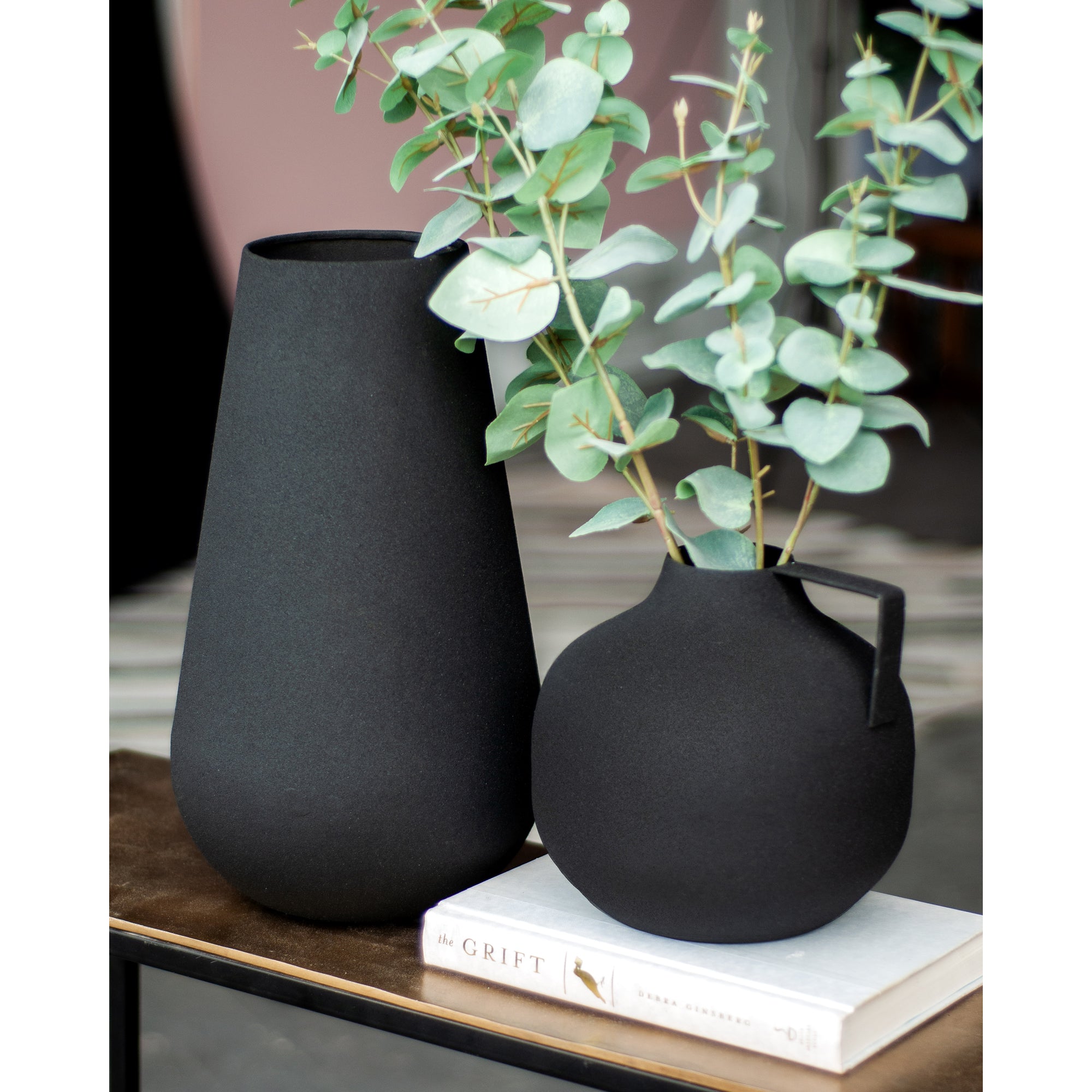 Roove Vase by Renwil, black vases with eucalyptus branches, displayed on a table with a book.
