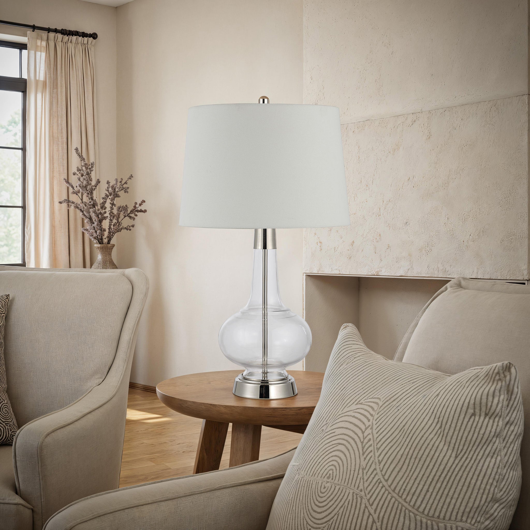Lya Table Lamp in a living room setting on a wooden table, surrounded by cozy seating.