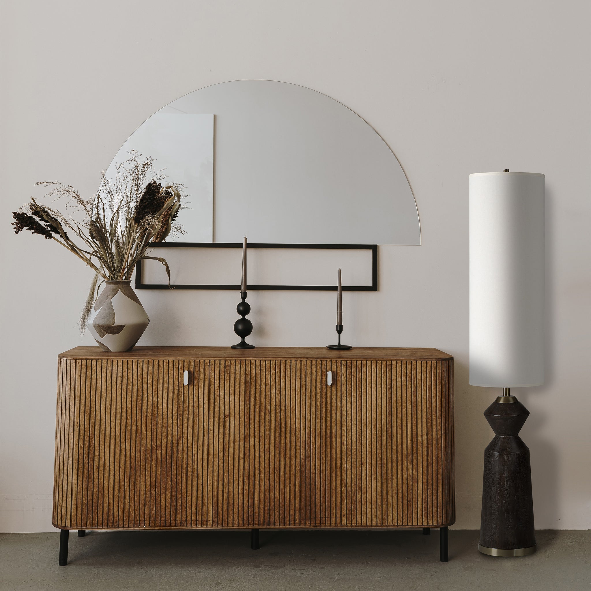 Pixel floor lamp beside a wooden sideboard with a mirror and decorative vase