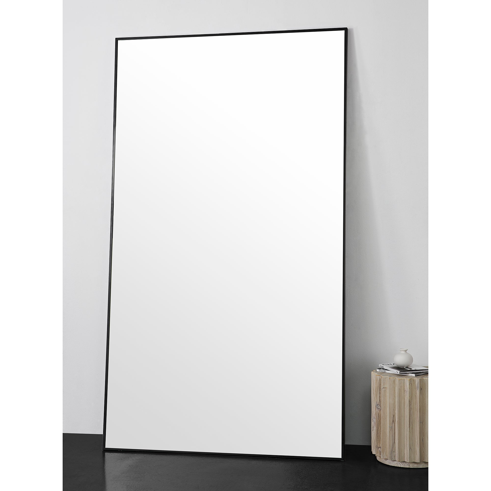 Keene Full Length Mirror positioned against a wall, showcasing its large reflective surface.