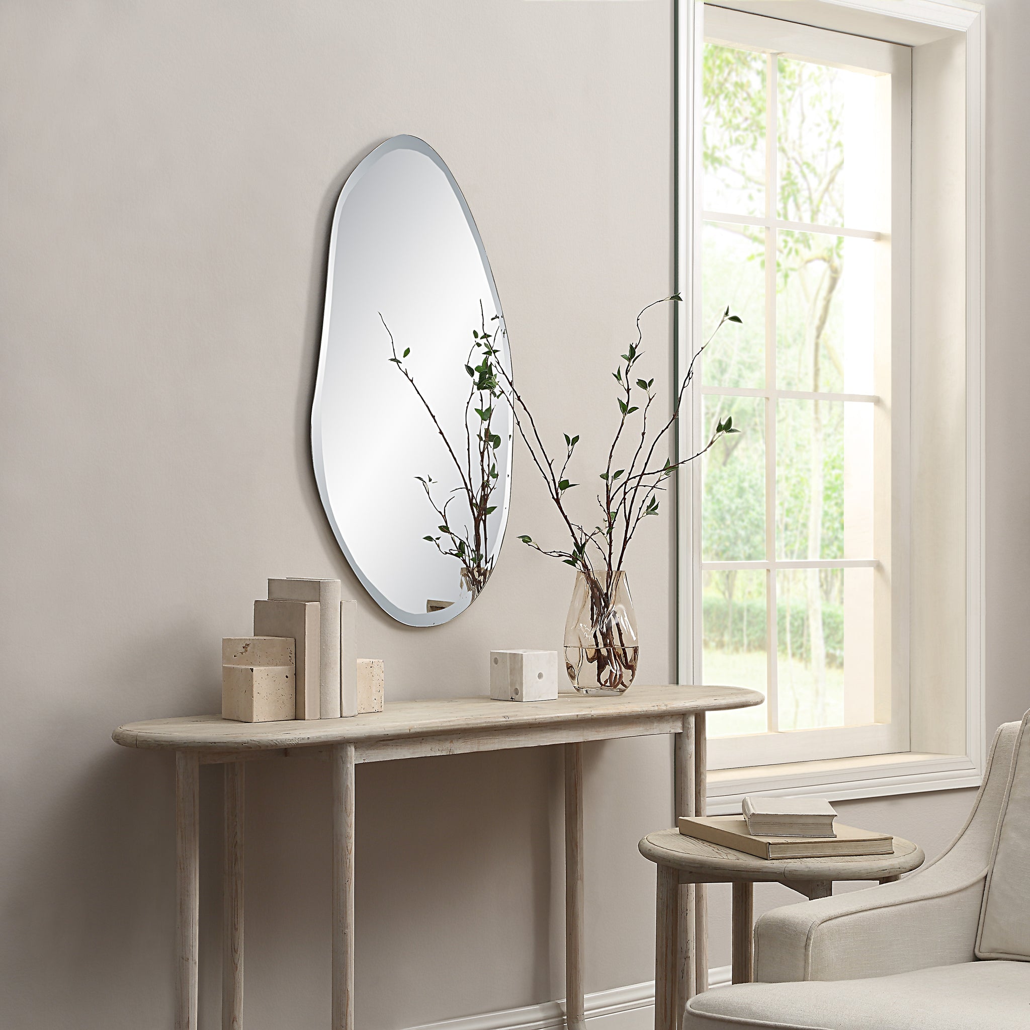 Anogia mirror by Renwil displayed in a room, mounted on wall above a console table with decor.