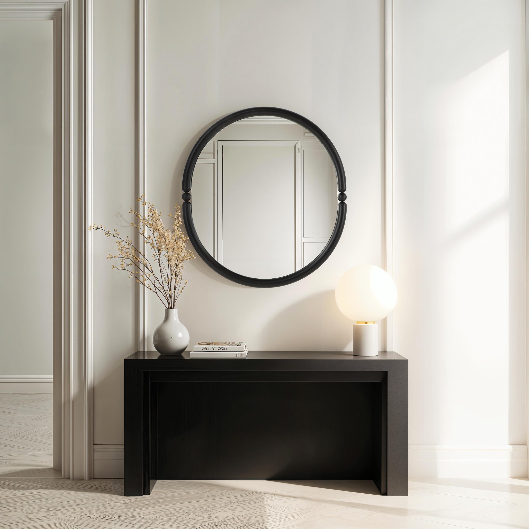 Ditto mirror with a black circular frame, displayed above a sleek black console table with a vase and lamp.