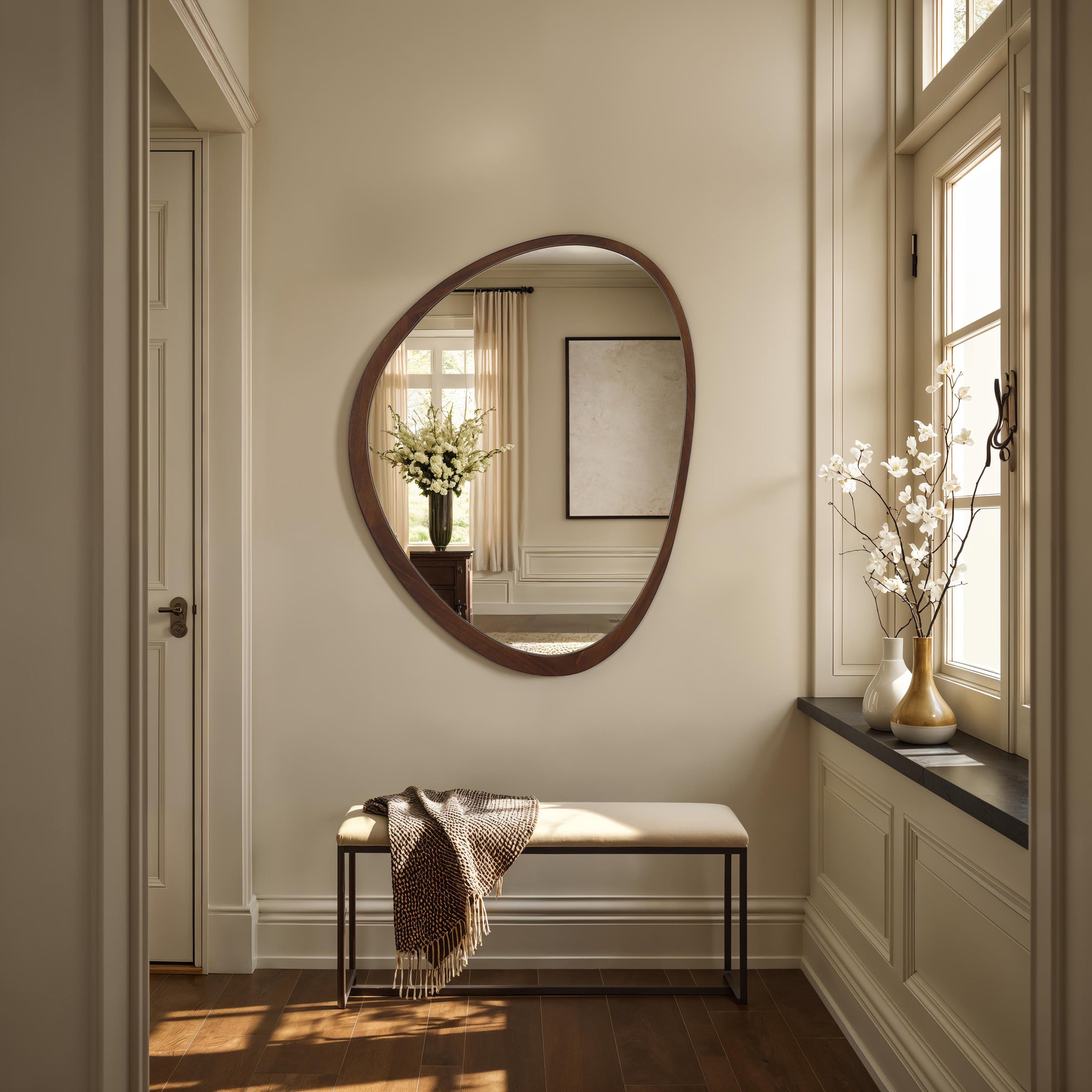 Borago mirror displayed in a stylish entryway with a bench and floral decor.