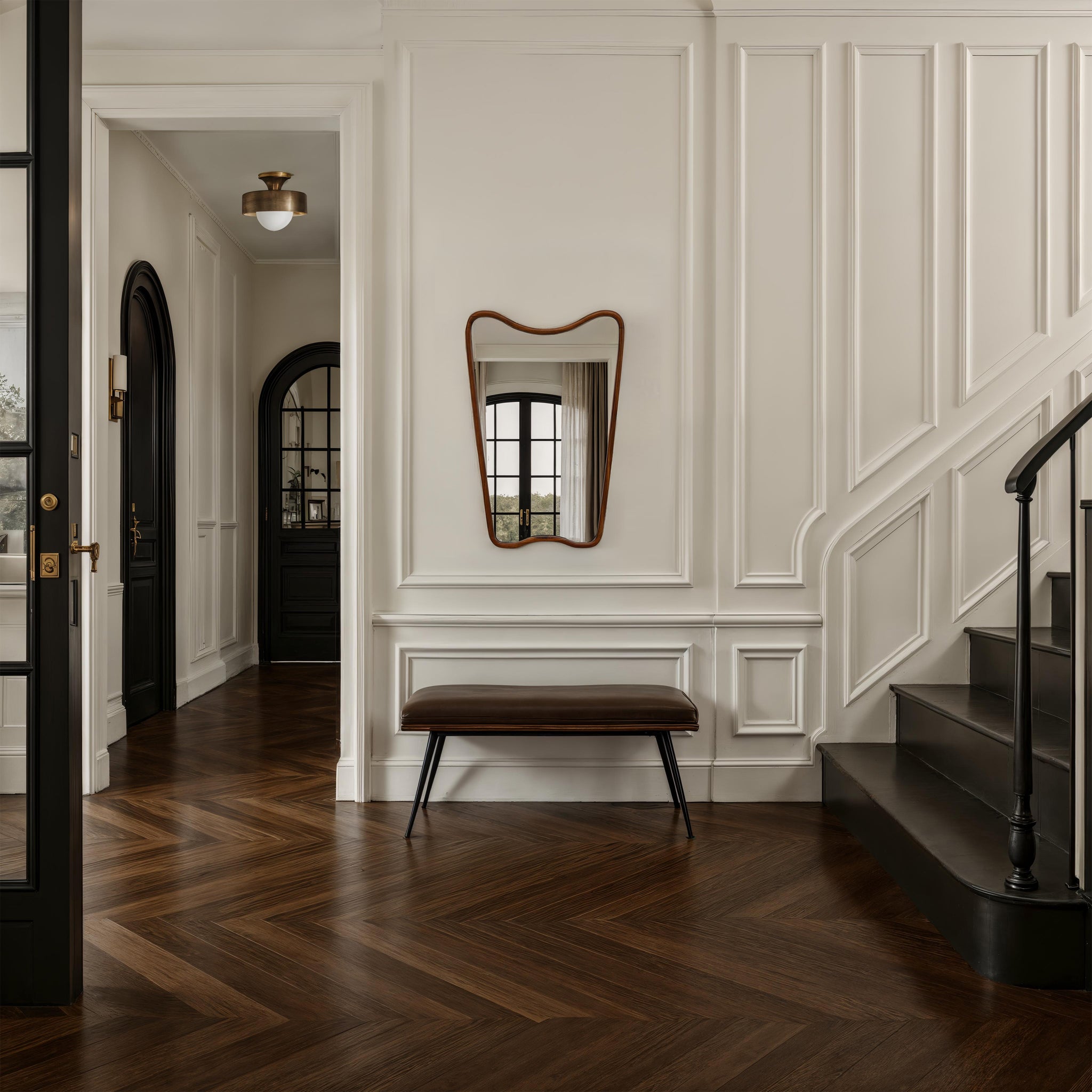 Reverie mirror with a wavy wooden frame, mounted on a white wall in a stylish hallway.