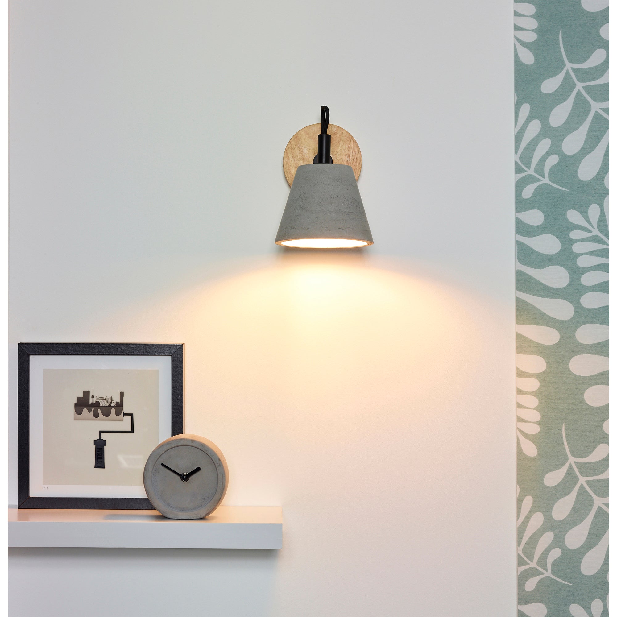 Turtle Bay Wall Sconce mounted on a wall, illuminating a space with a gray concrete shade and wood backplate.