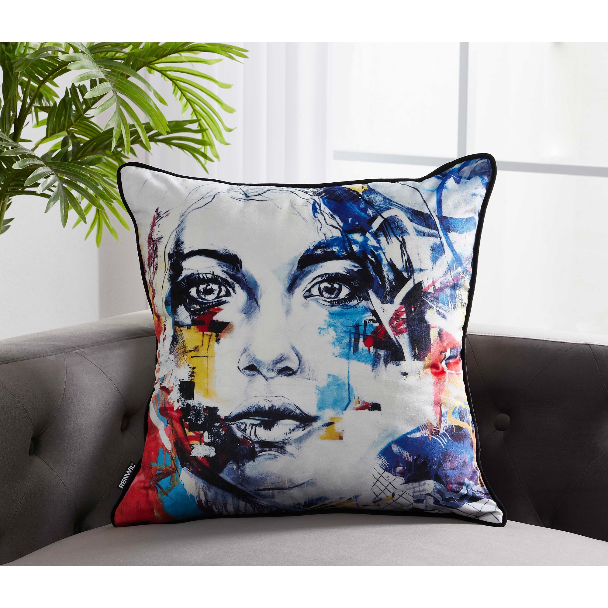 Tori Indoor Pillow displayed on a gray sofa, showcasing an artistic face print with vibrant colors.