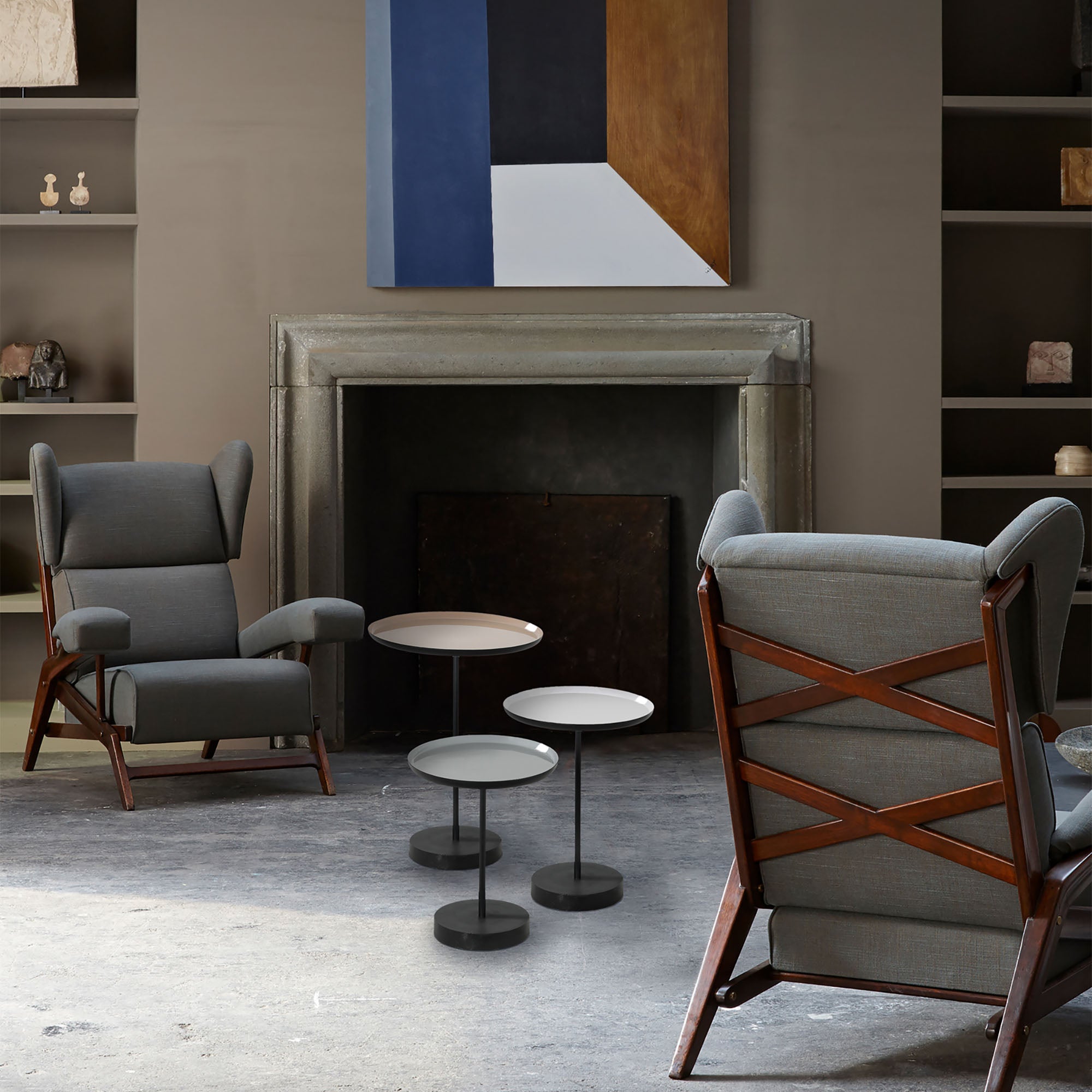 Stepping Indoor Iron Table trio in a living room setting, paired with a gray armchair and modern decor.