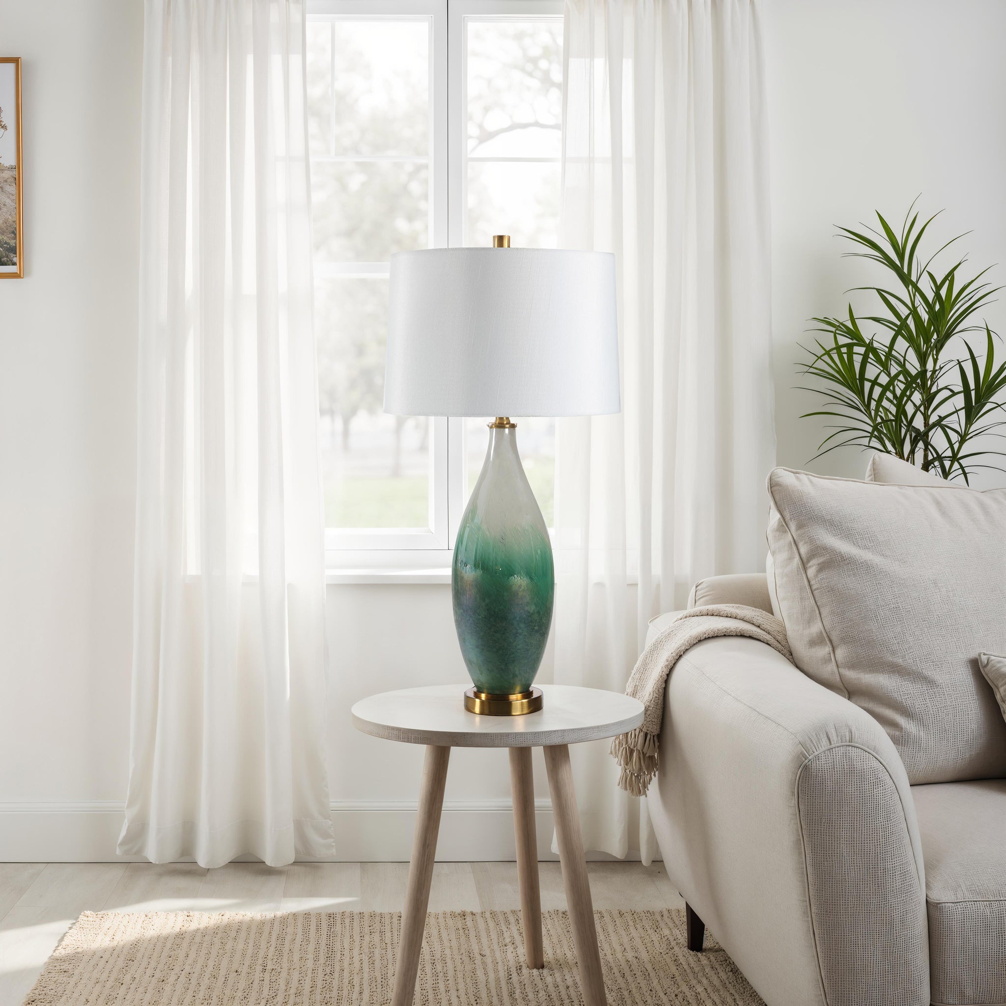 Wave table lamp placed on a side table in a living room, showcasing its green glass base and white shade