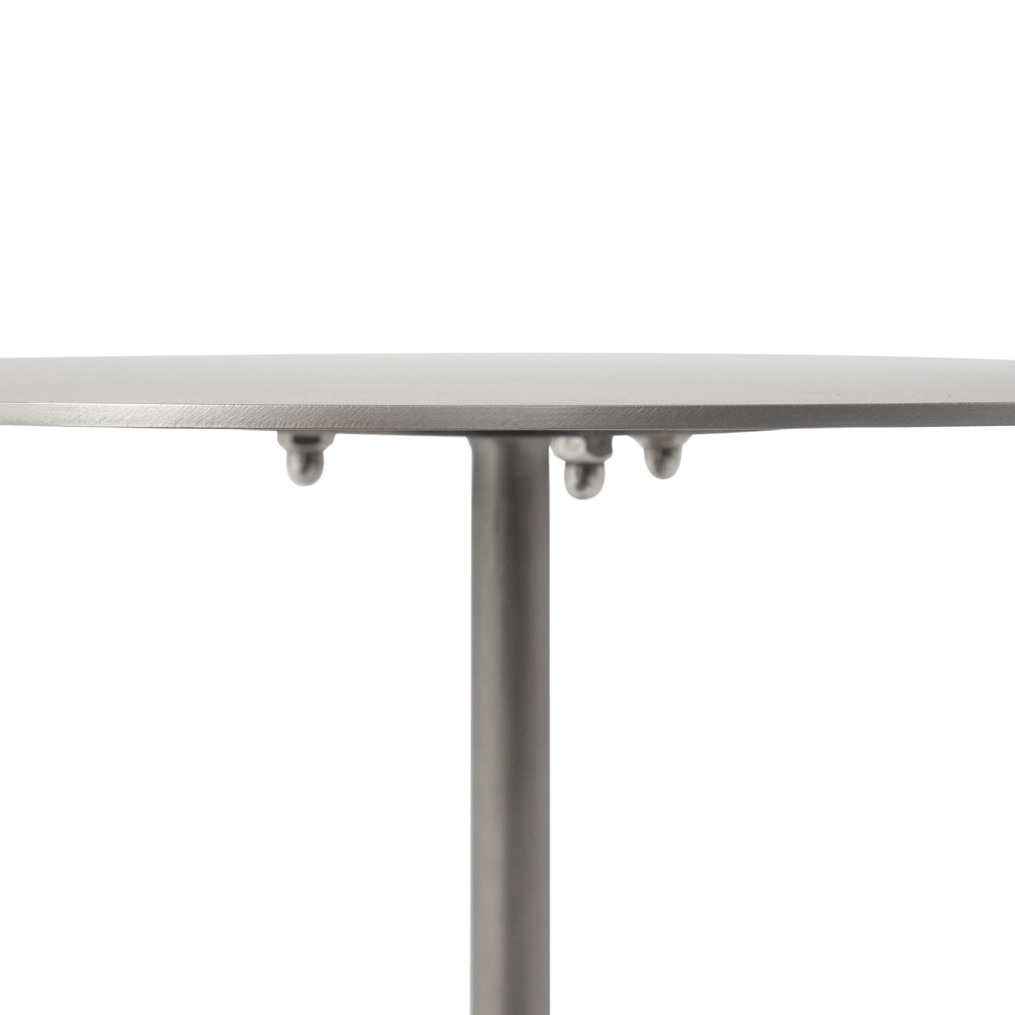 Close-up of Aiden side table's round metal top with three small support points.