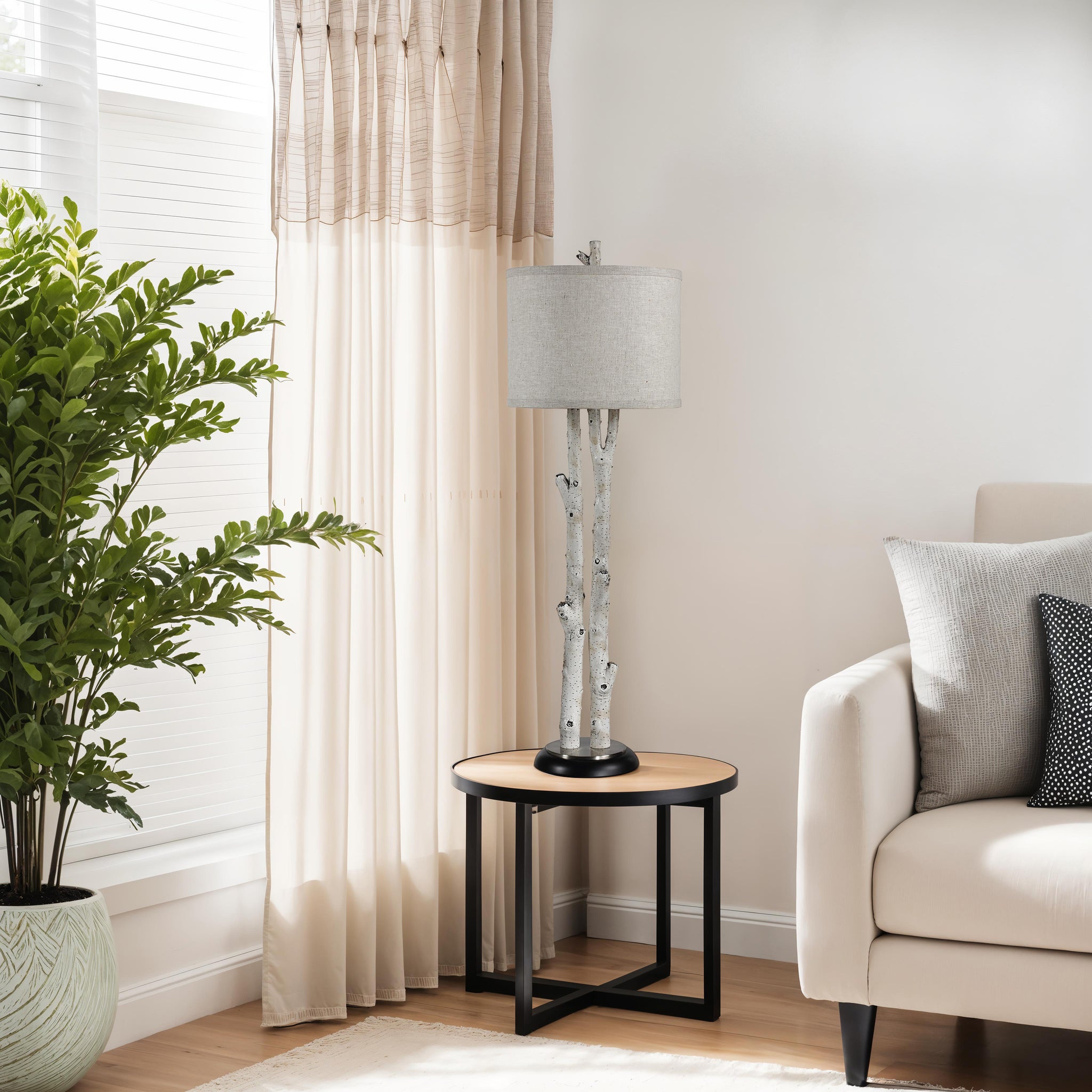 Leandro Table Lamp placed beside a beige sofa on a wooden side table.