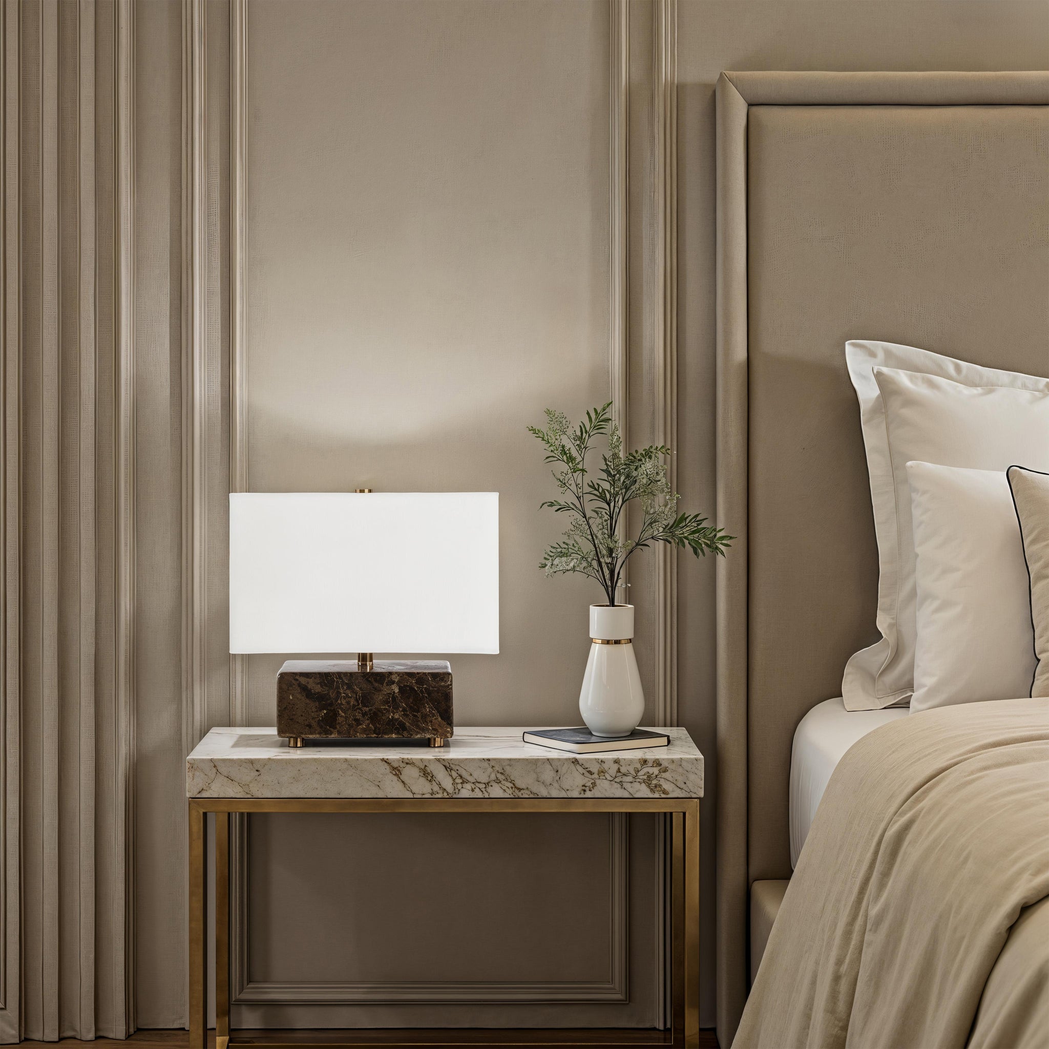 Cabo table lamp on a nightstand beside a bed, with a vase and book.