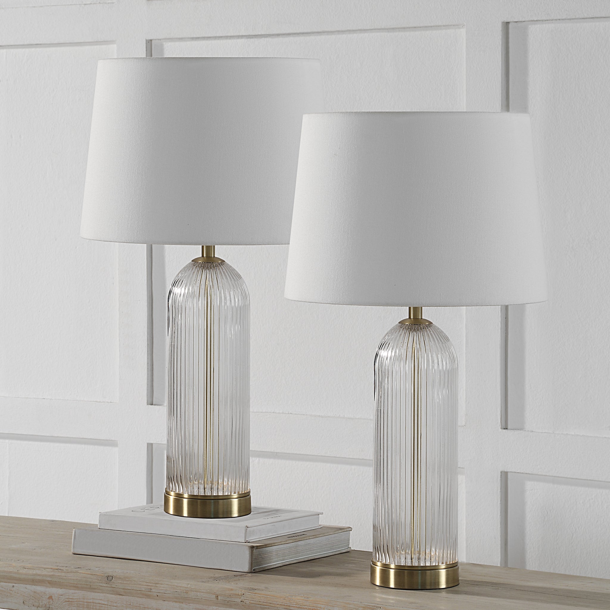 Ocala Table Lamp set of two on a wooden table with books and a white wall backdrop