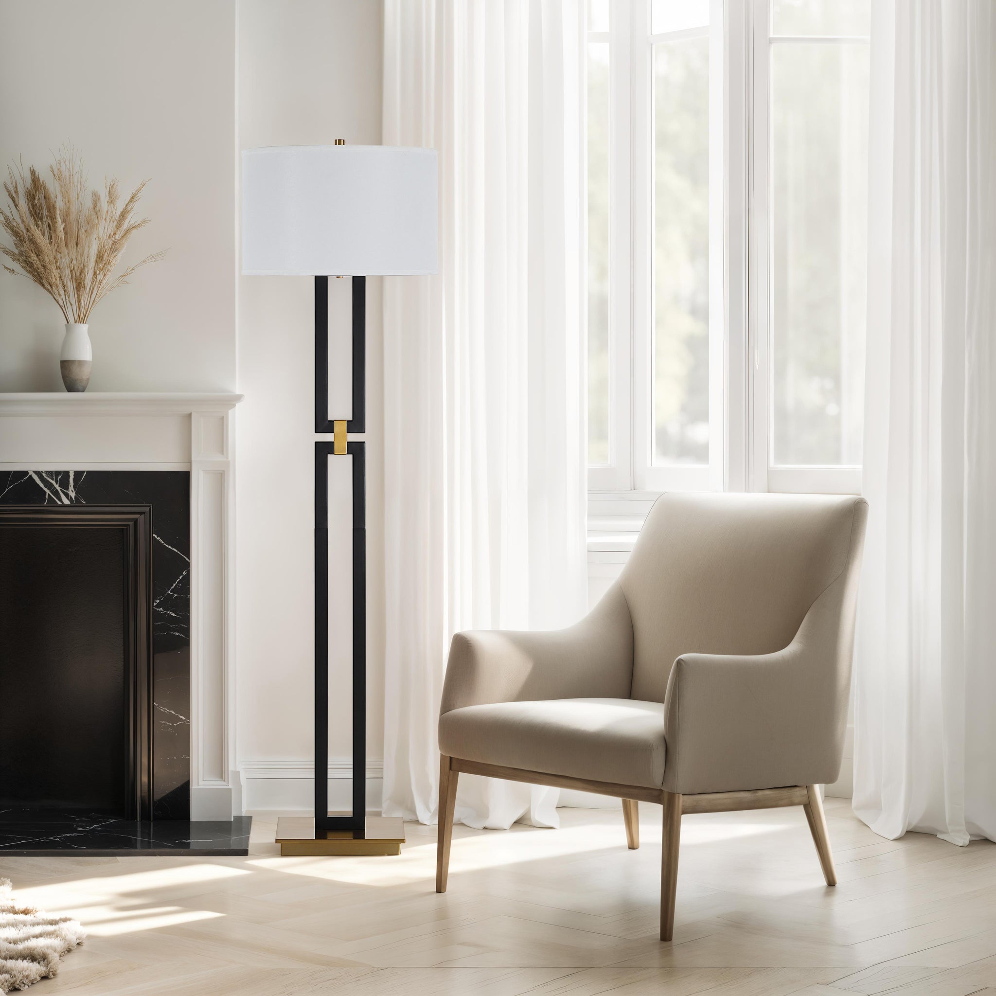 Theo Floor Lamp beside a beige armchair in a bright room with large windows.