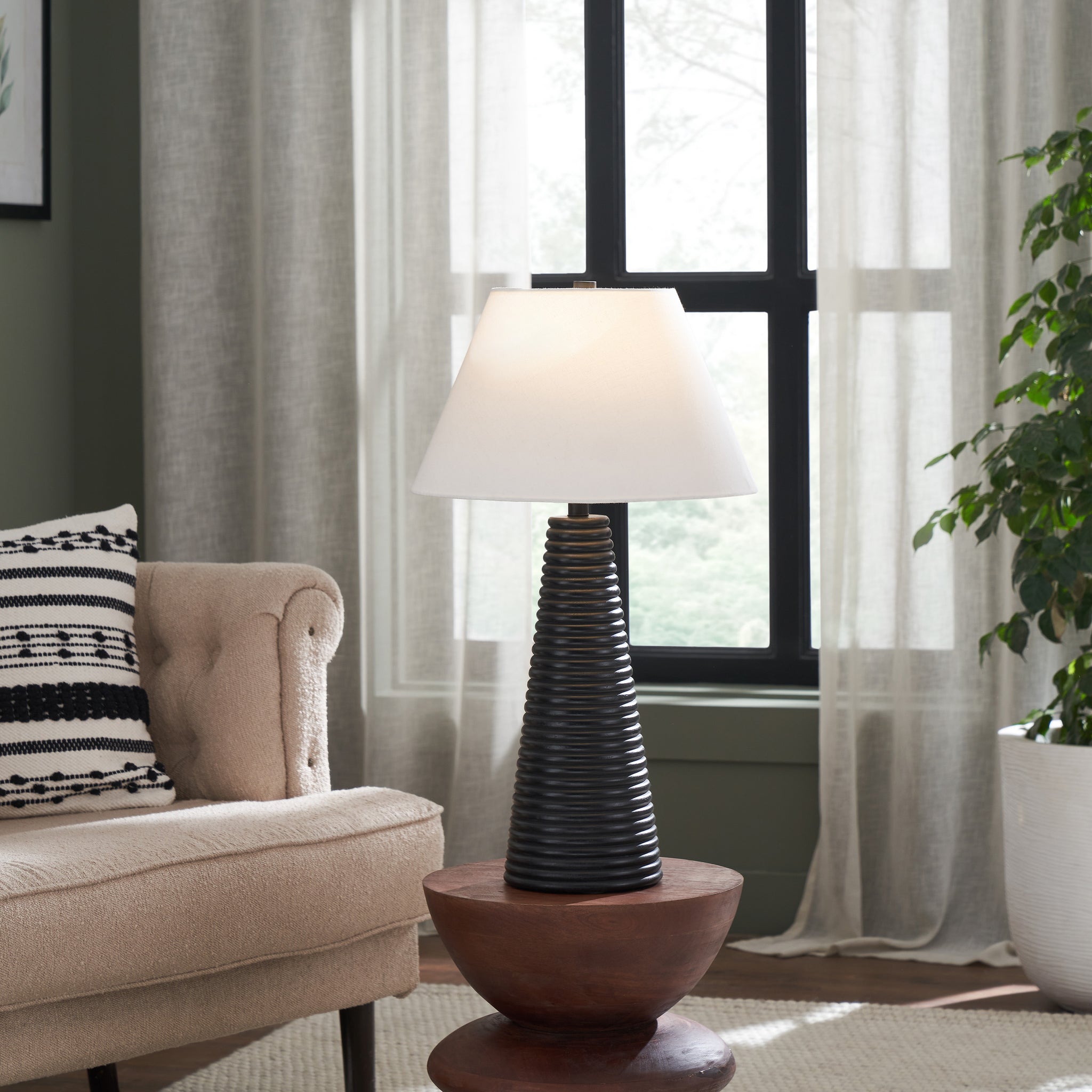 Kailua Table Lamp in a living room setting on a wooden table beside a beige couch.