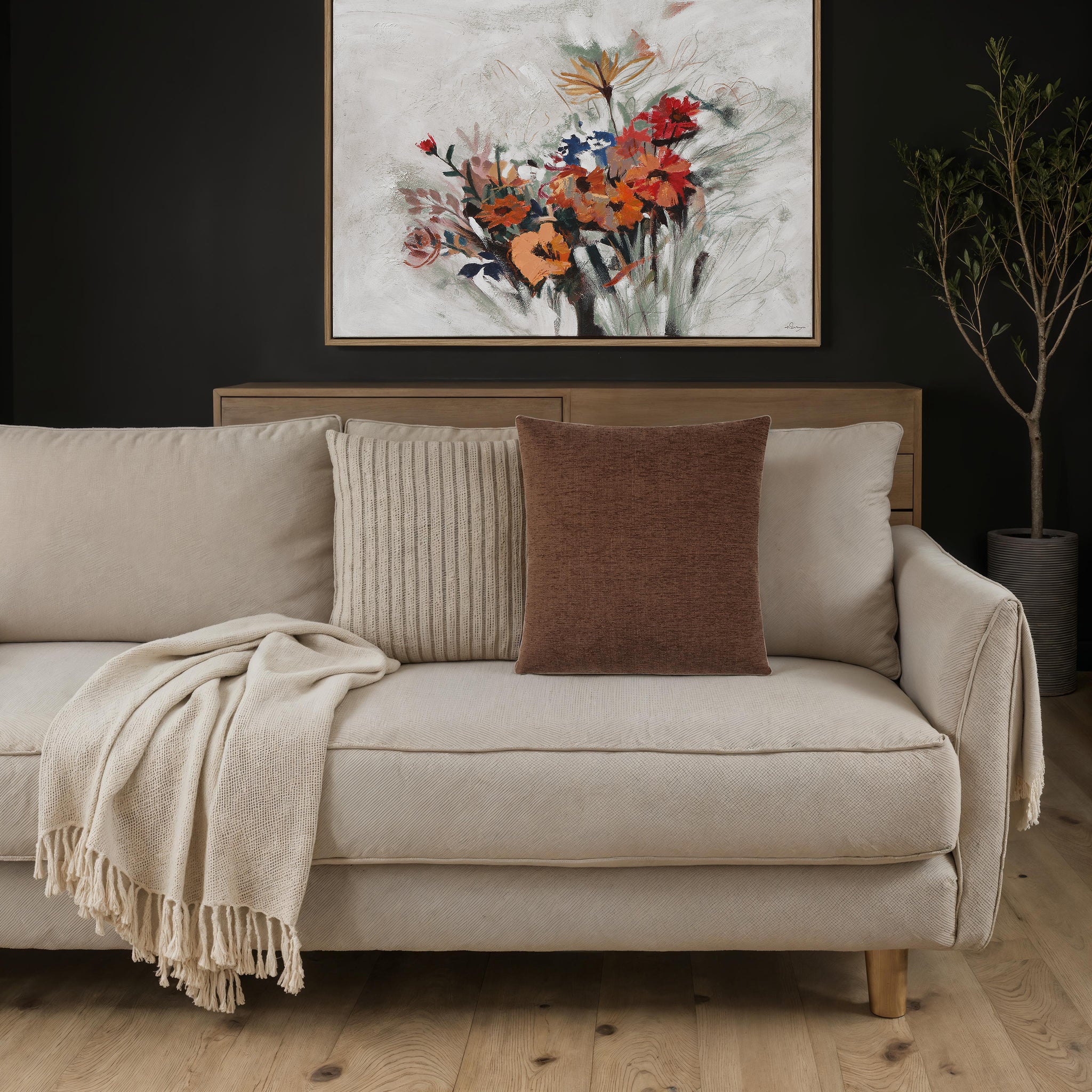 Ferro pillow in brown placed on a cozy beige sofa with decorative elements.