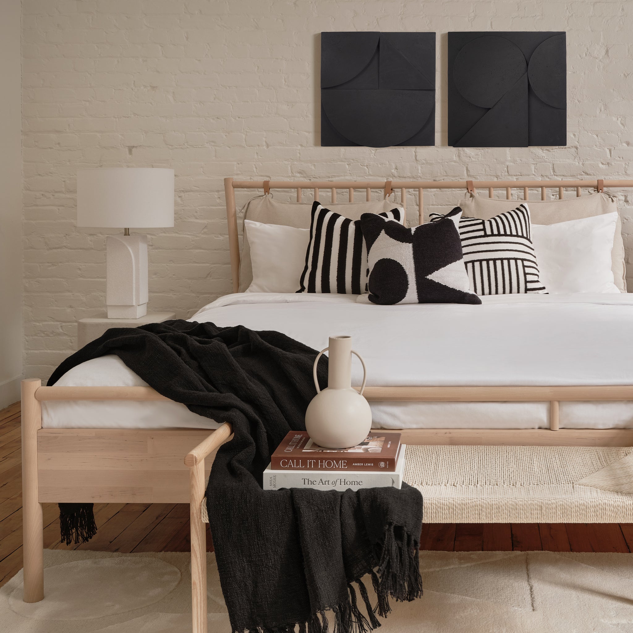 Serino wall decor displayed above a bed with decorative pillows and a lamp.