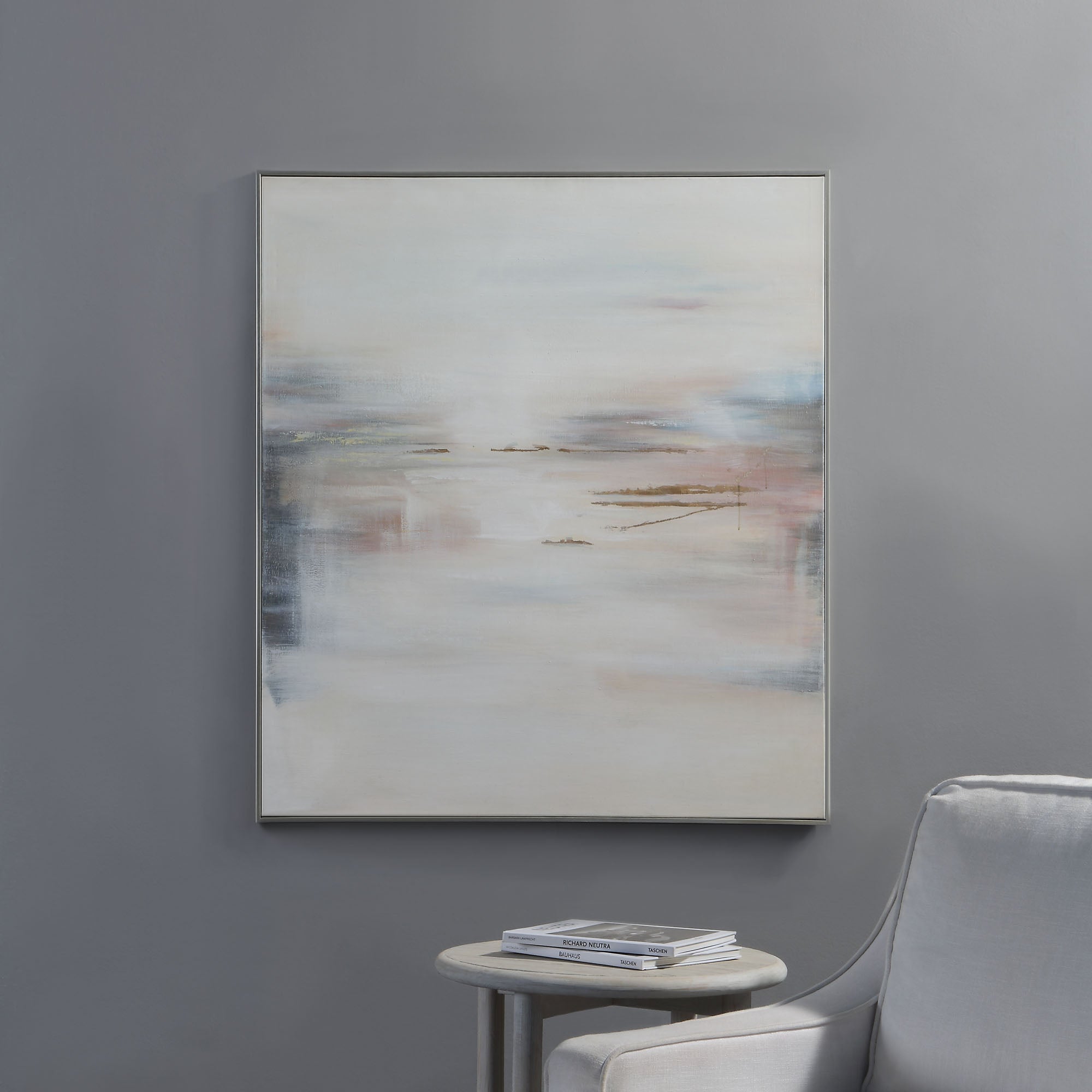 Carina Canvas Art hung on a gray wall beside a light gray chair and a small table.