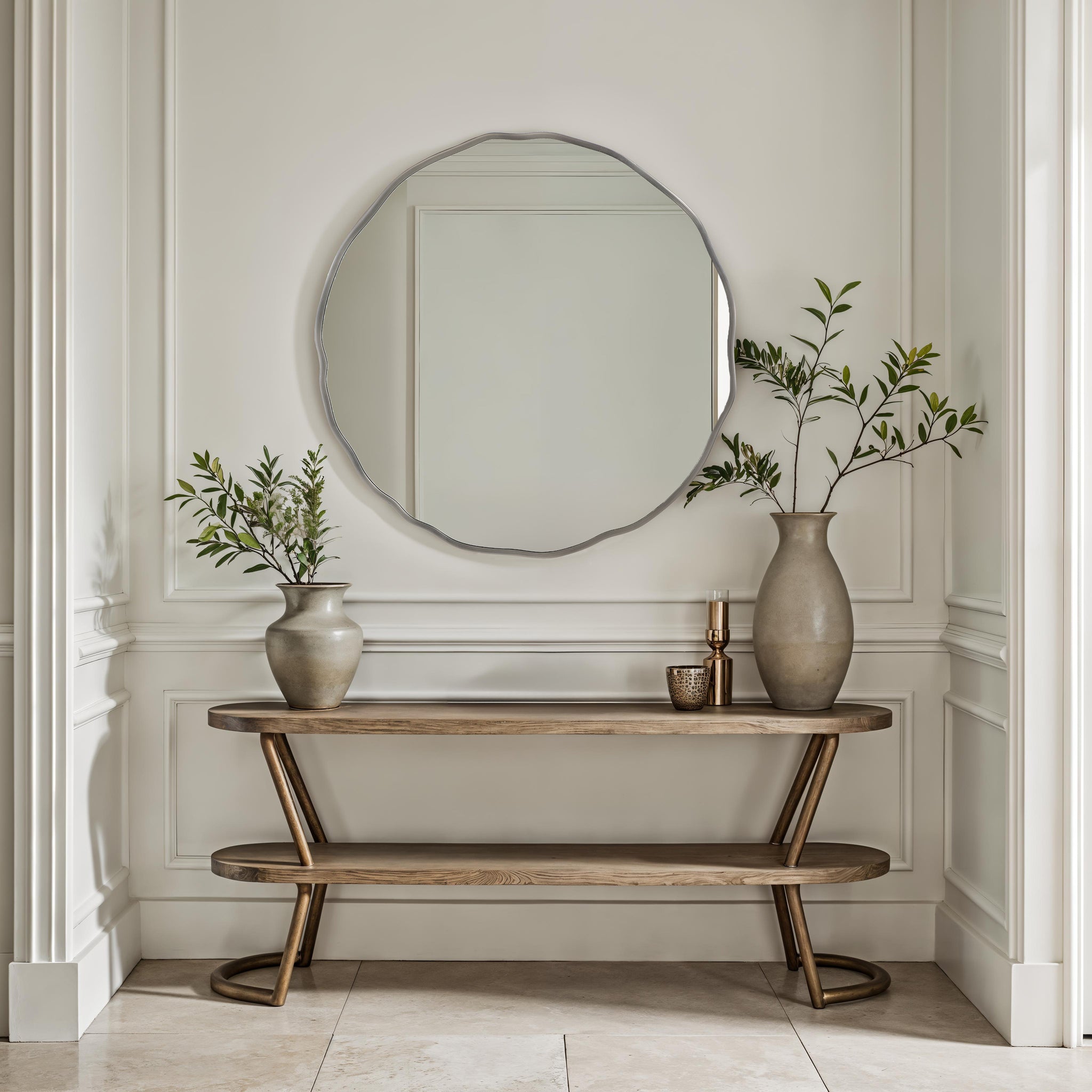 Cerro mirror by Renwil displayed above a wooden console table with vases and greenery.