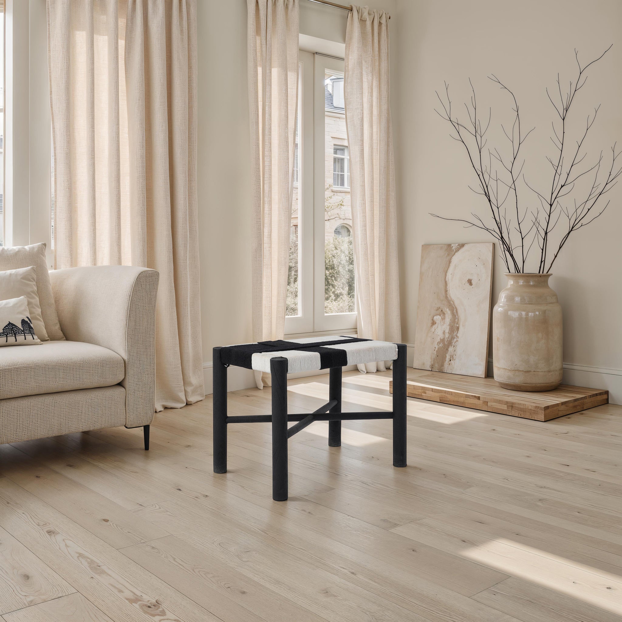 Plex stool by Renwil in a living room setting, with natural light and beige curtains in the background.