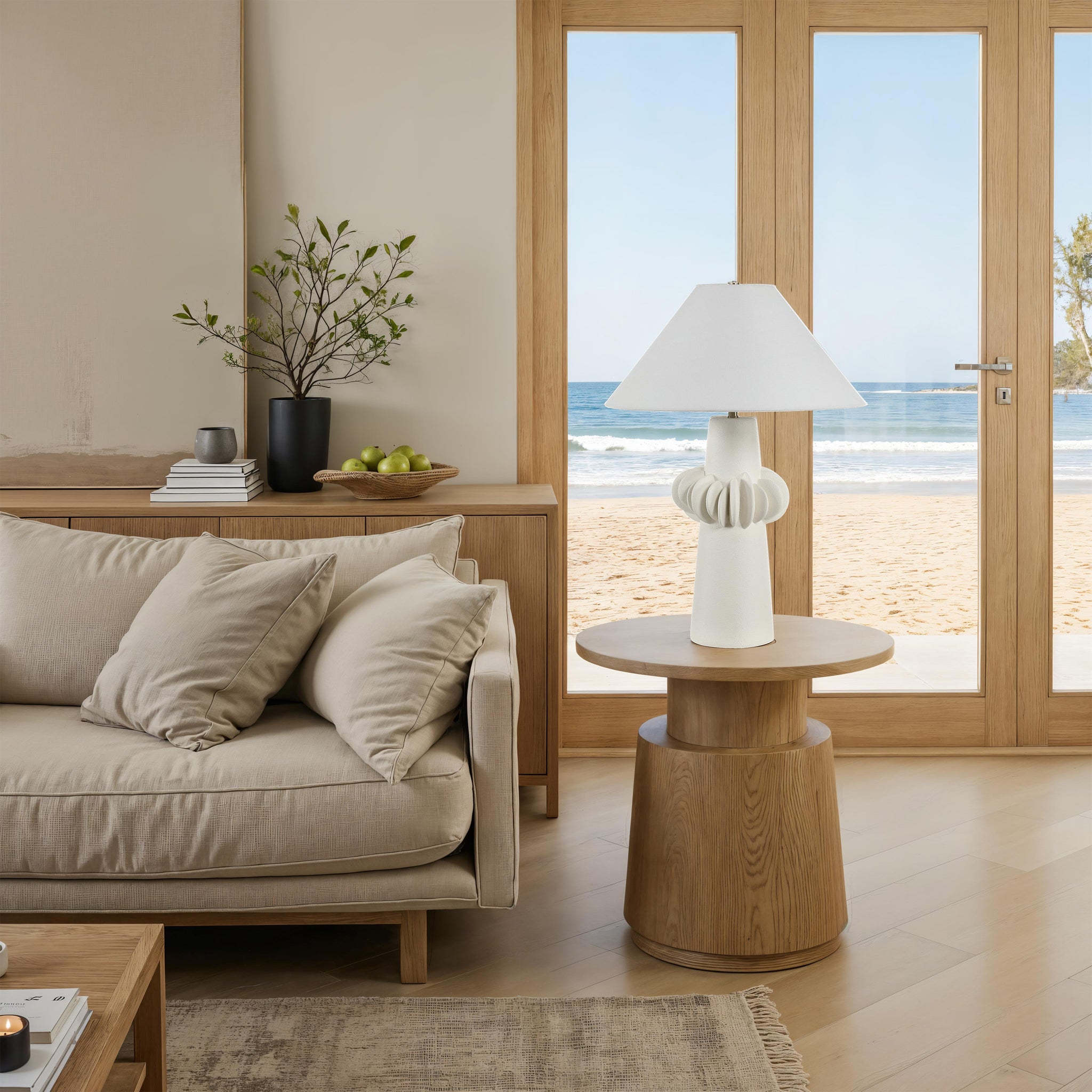 Disla Table Lamp on a round wooden side table in a beachside living room