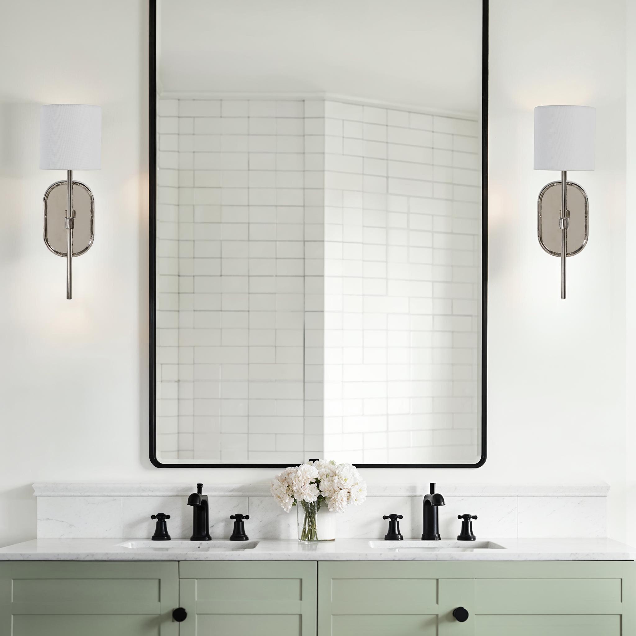 Whitney wall sconces installed in a modern bathroom with a large mirror