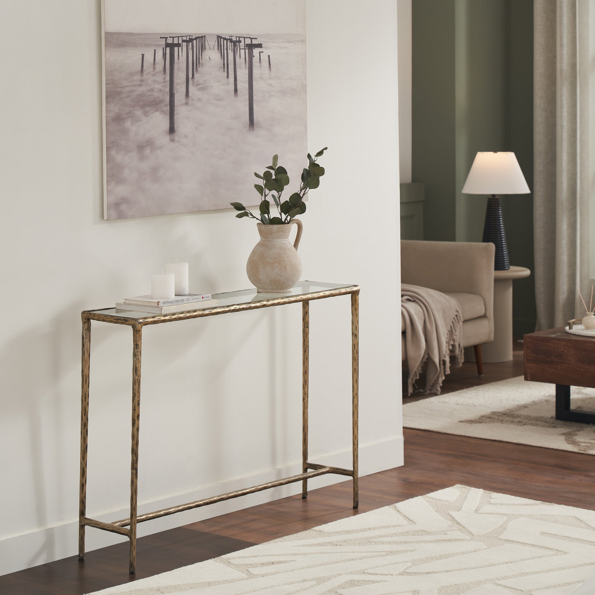 Nara console table styled in a living room with decorative items and a plant.