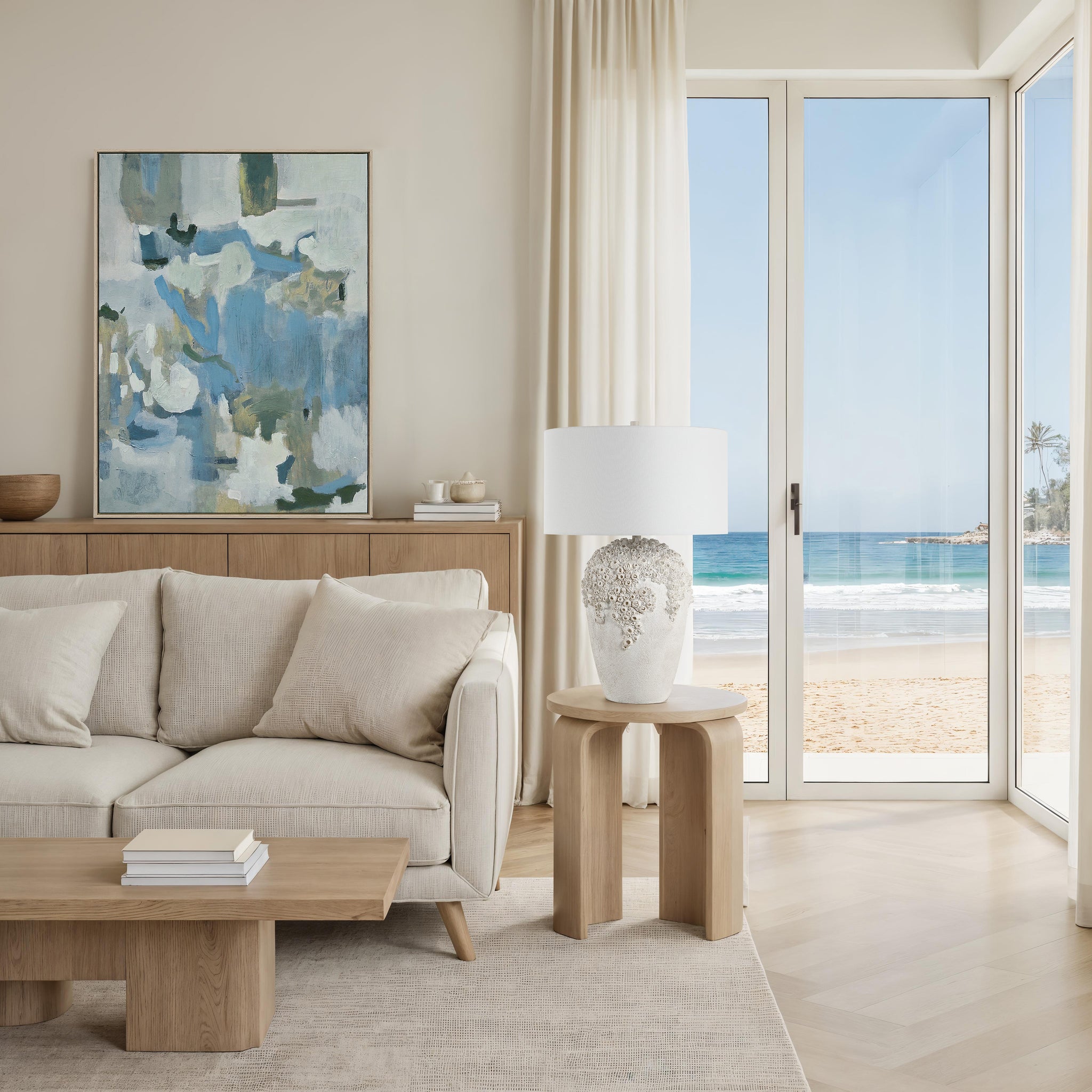 Wavy table lamp beside a modern sofa in a light-filled room with ocean view