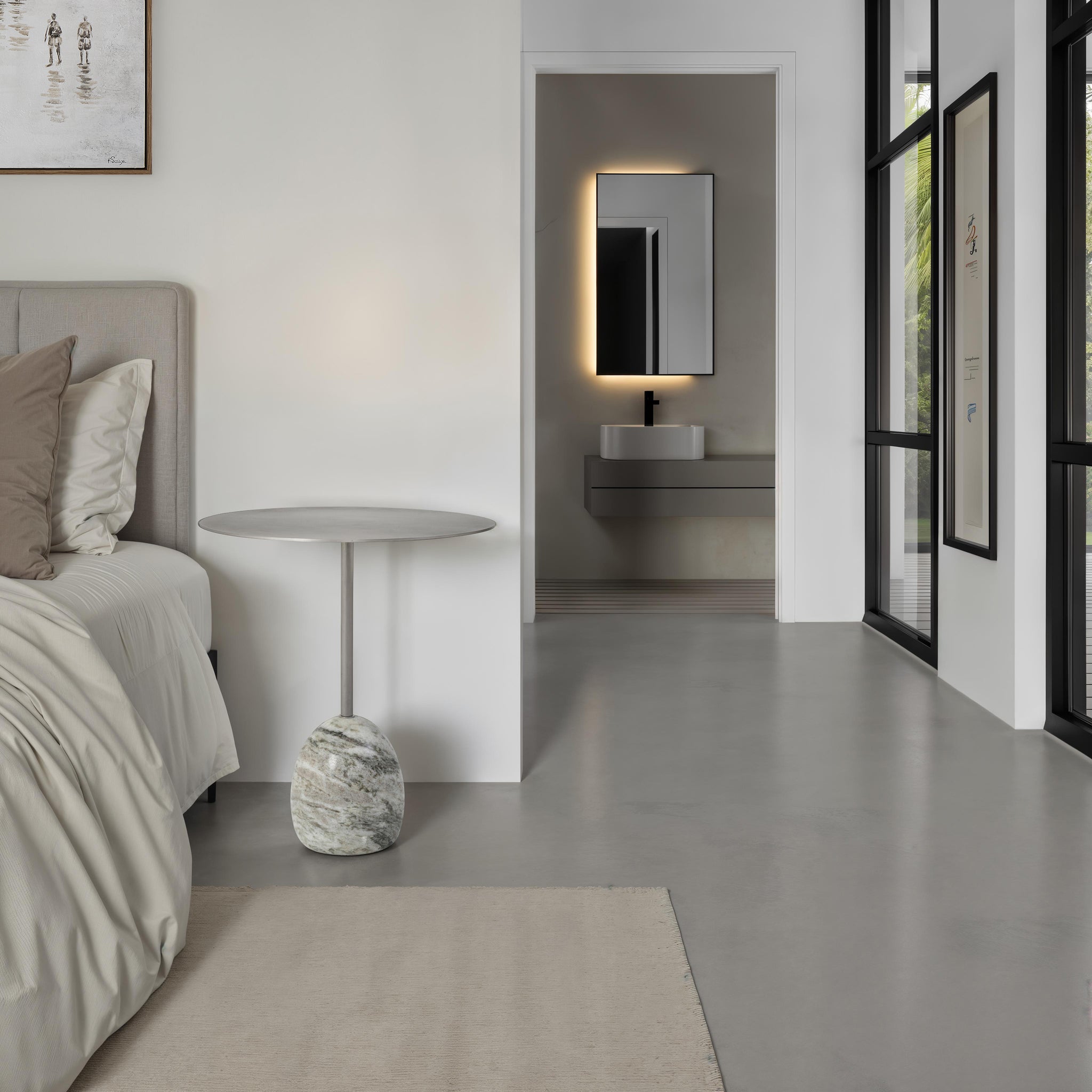 Aiden side table positioned next to a bed in a modern bedroom with a minimalist design.