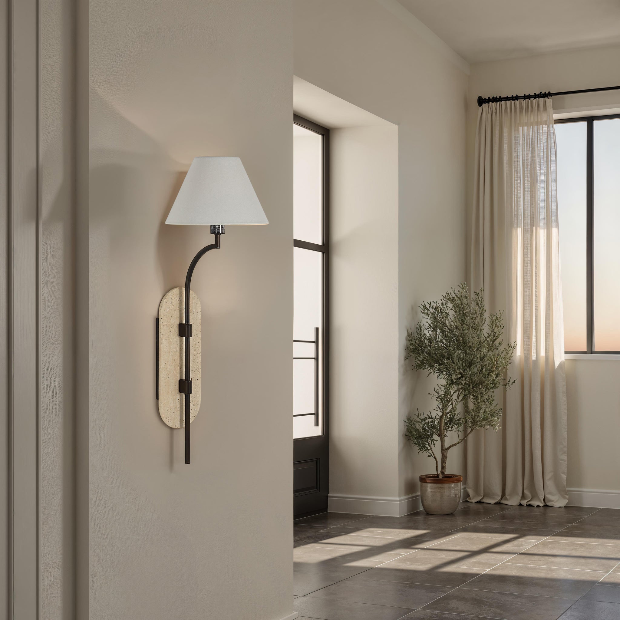 Acca Wall Sconce in a stylish entryway with natural light and a potted plant